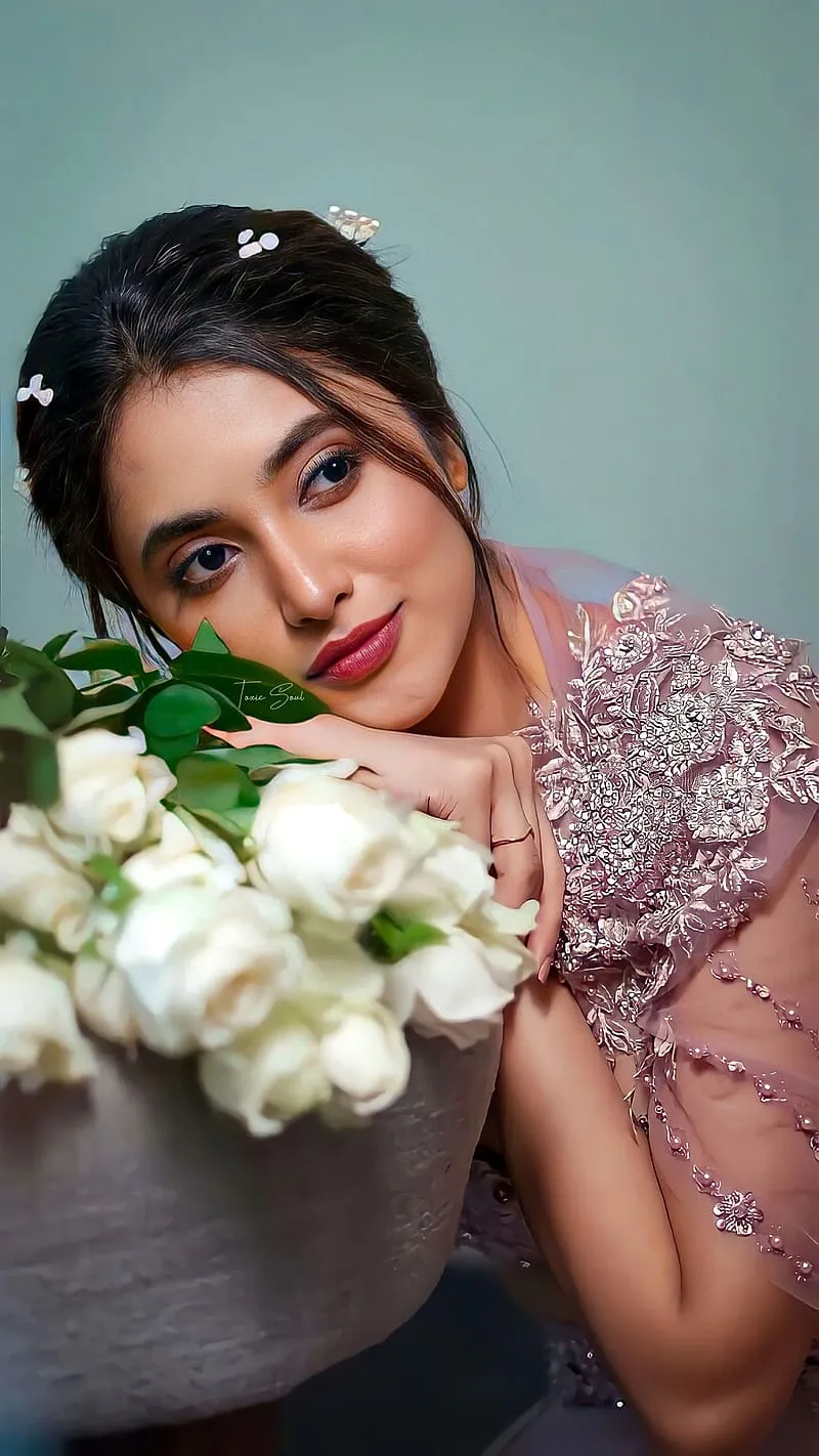 Priyanka in soft pink dress resting on white flower bouquet