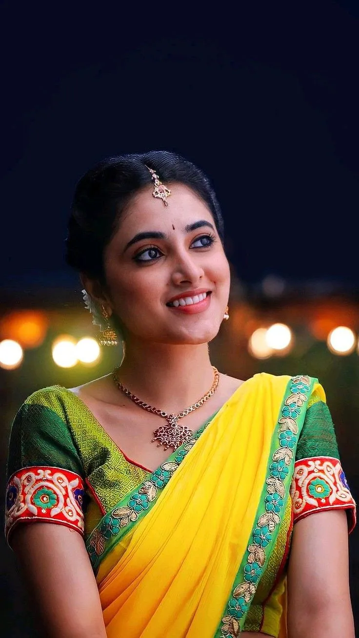 Priyanka in yellow saree smiling gracefully with charm image