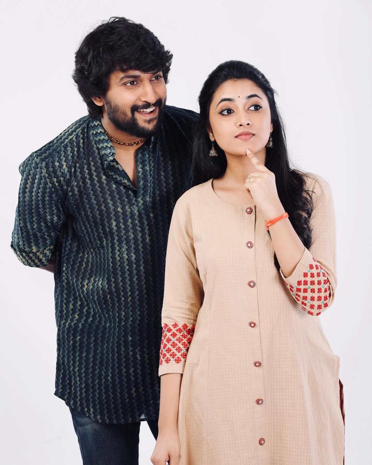 Priyanka Mohan And Nani Standing Against a White Background