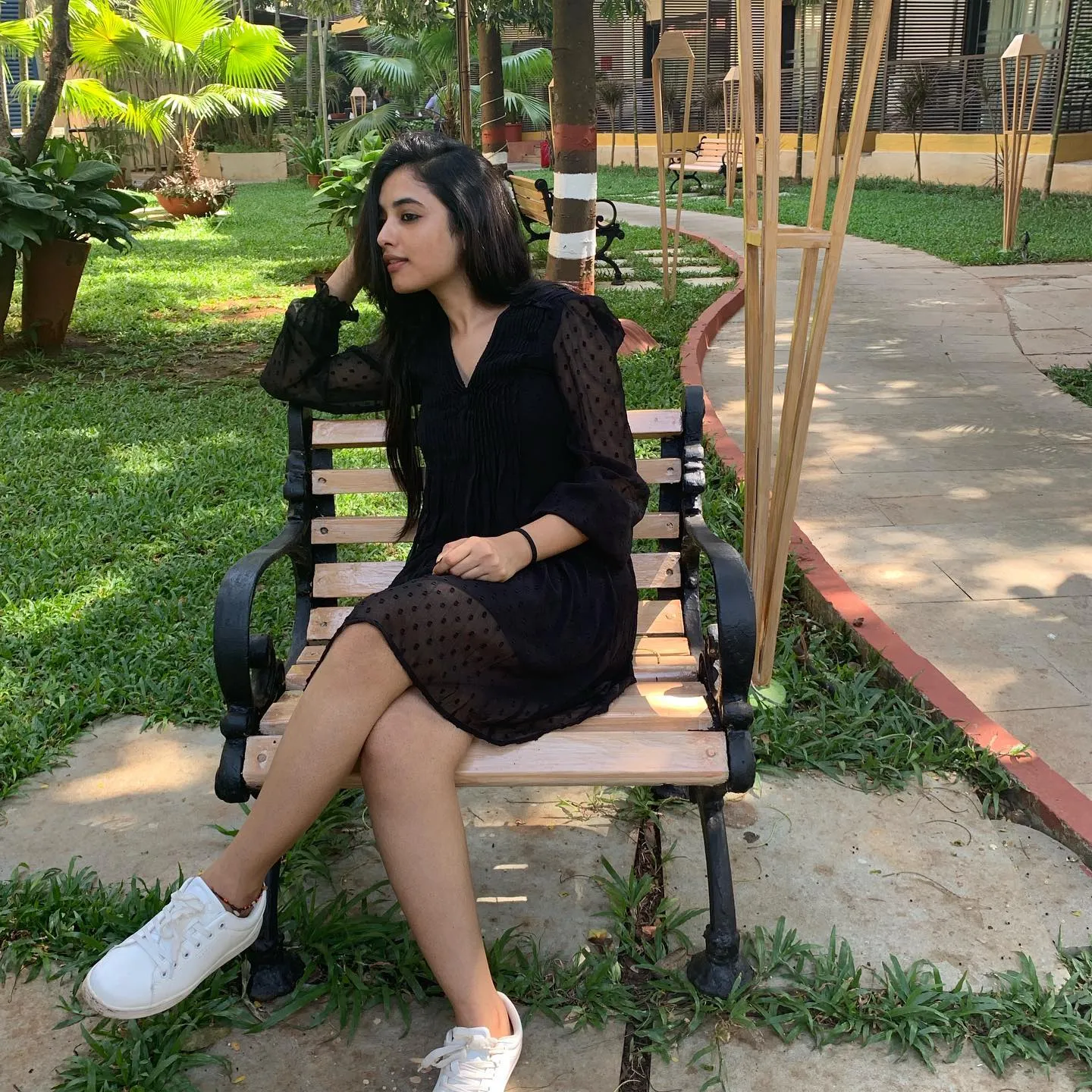 Priyanka Mohan in a Black Dress Sitting on the Park Bench