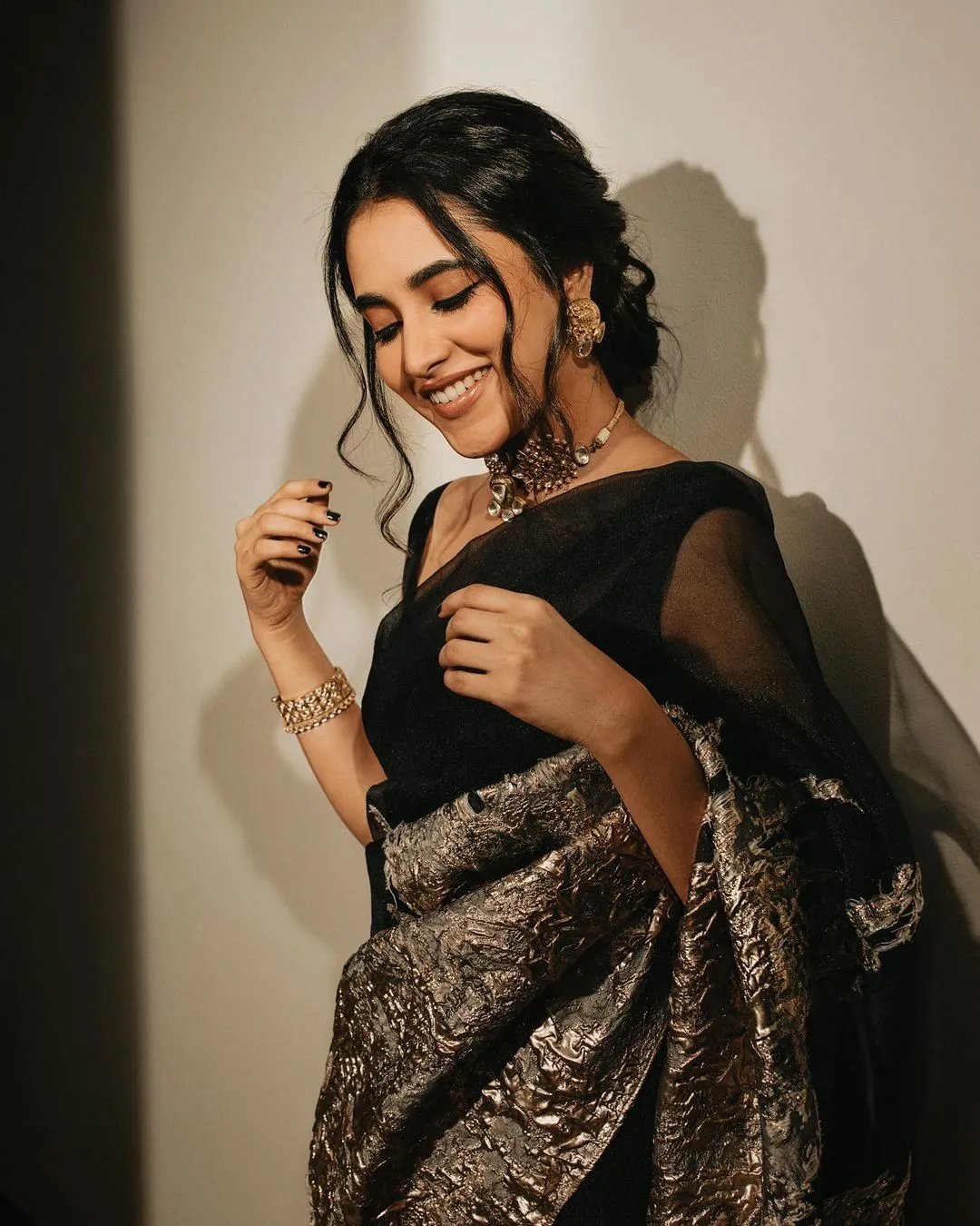 Priyanka Mohan in a Black Saree Standing Near a White Wall