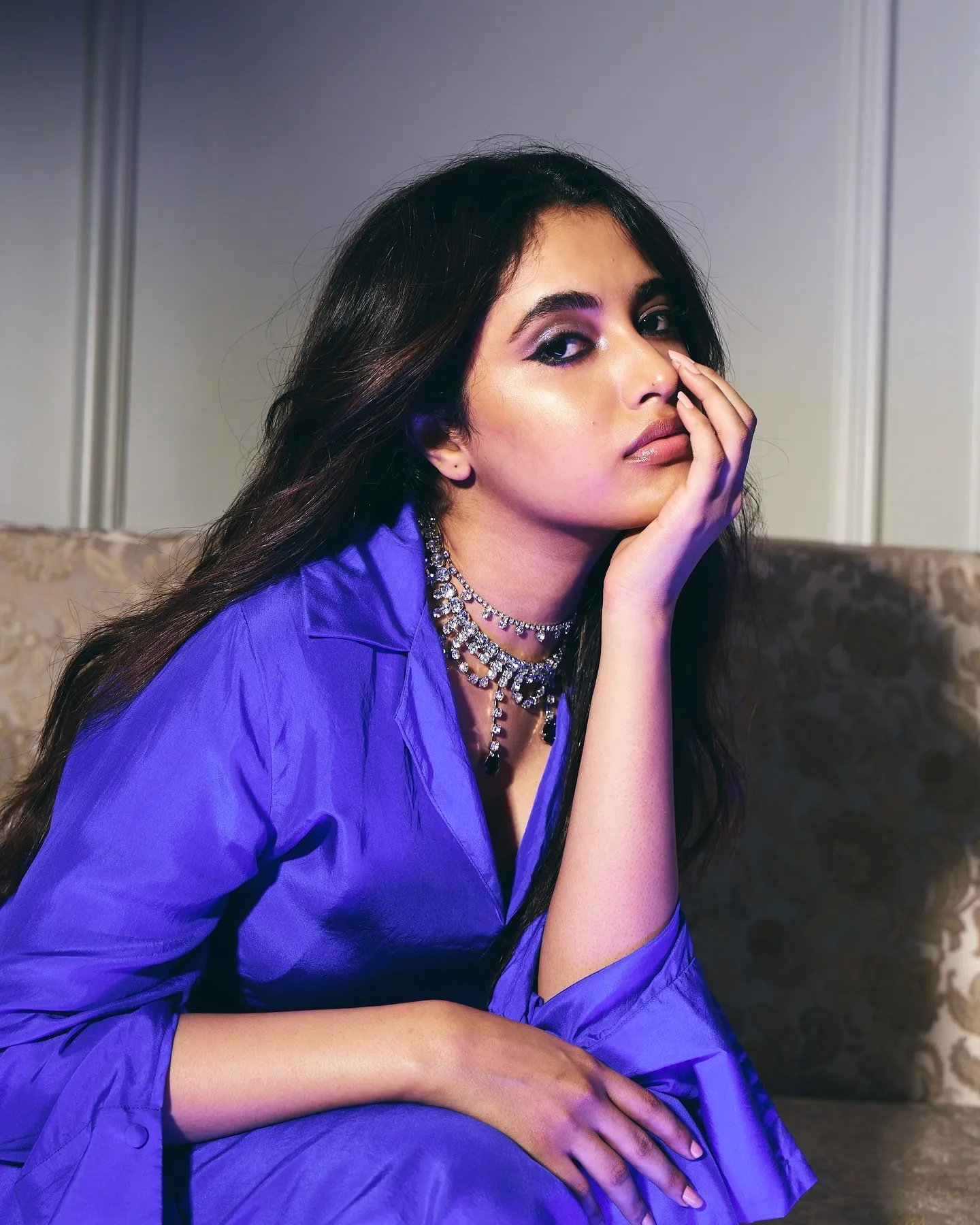 Priyanka Mohan in a Blue Dress Sitting on a Couch Wallpaper