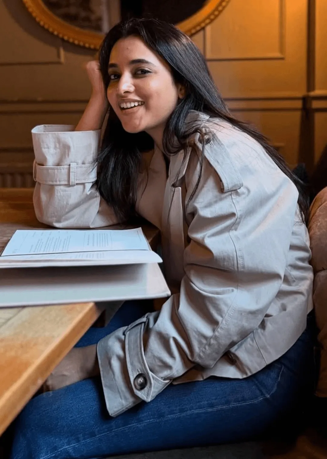 Priyanka Mohan in a Brown Trench Coat Sitting in Restaurant