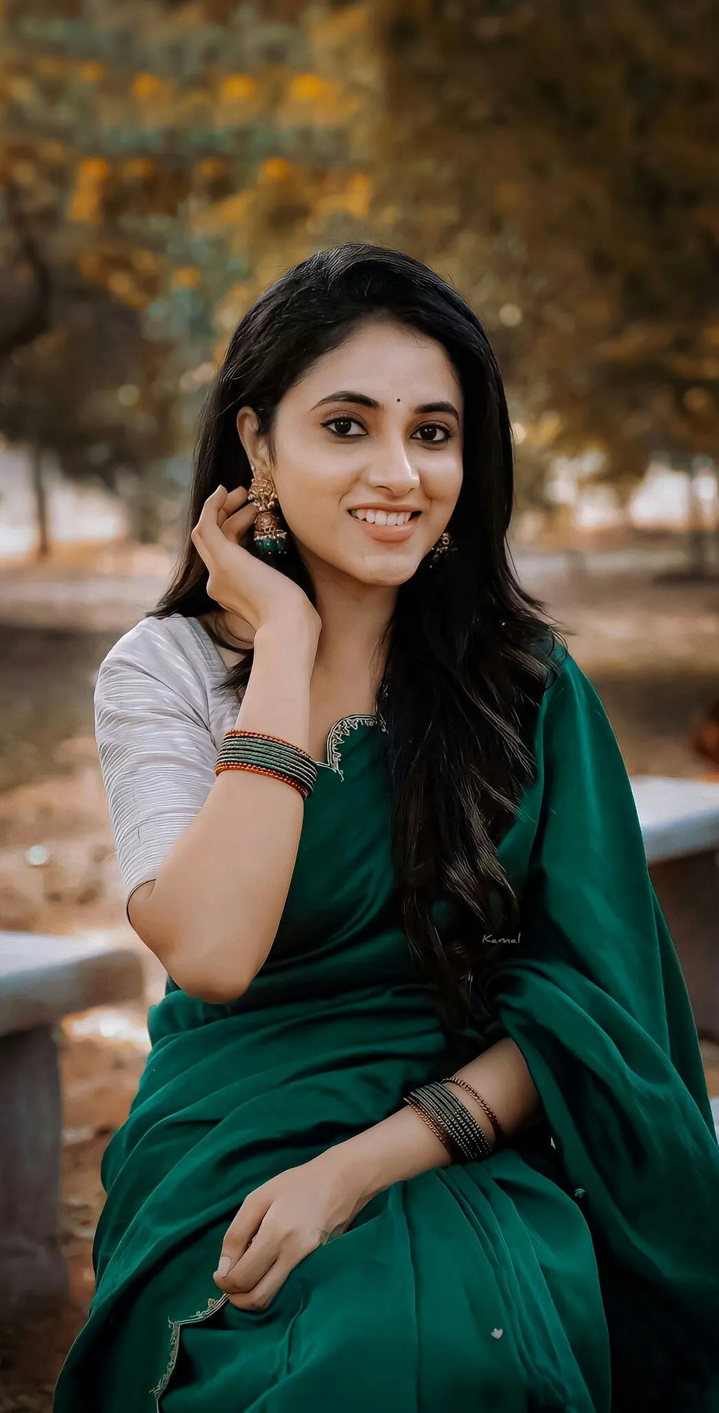 Priyanka Mohan in a Dark Green Saree Sitting in the Park