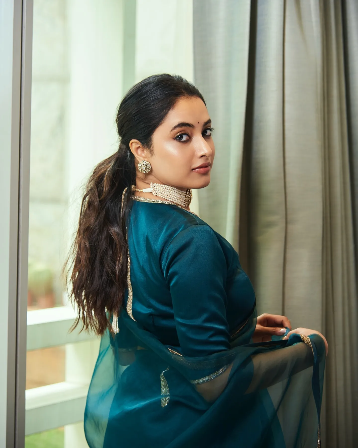 Priyanka Mohan in a Dark Green Saree Standing Near Curtain