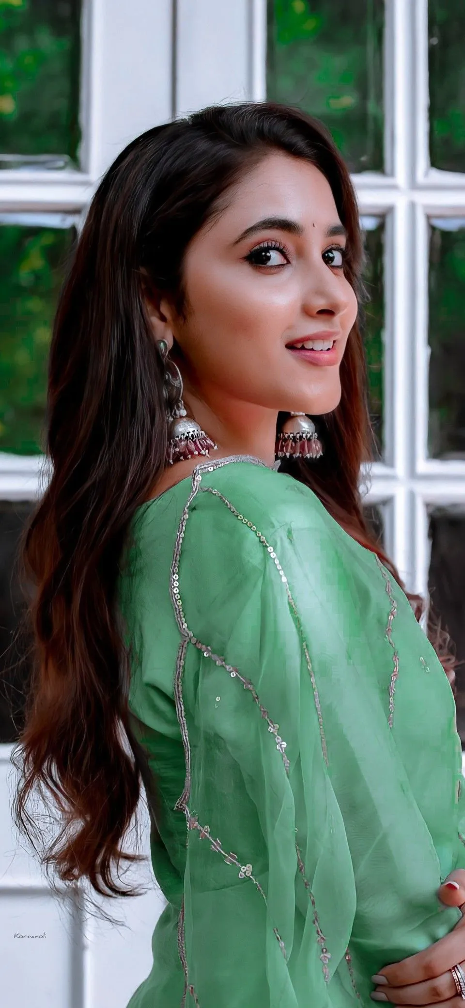 Priyanka Mohan in a Green Dress Standing Near the Window