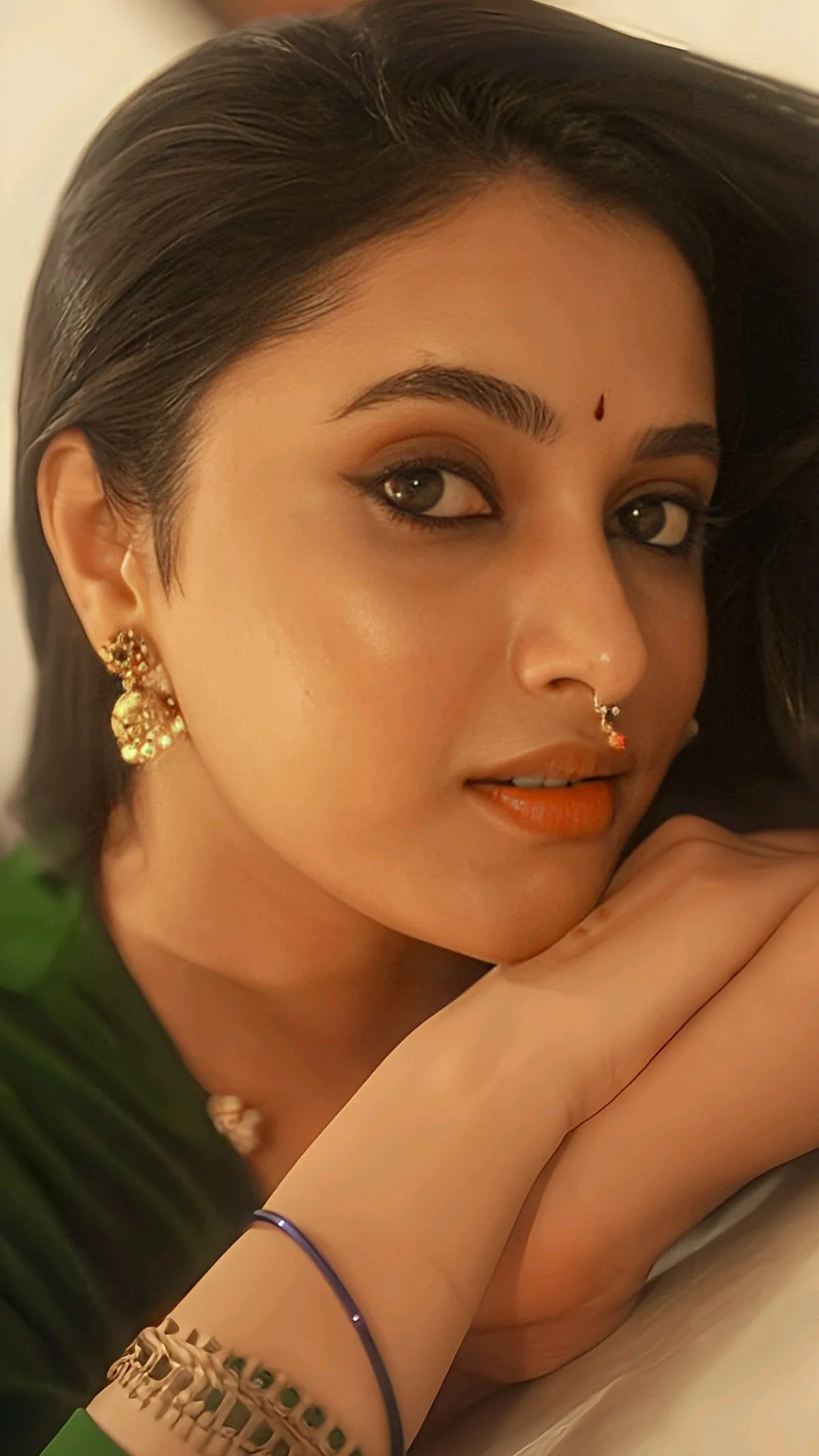 Priyanka Mohan in a Green Saree Lying with Her Hand Image