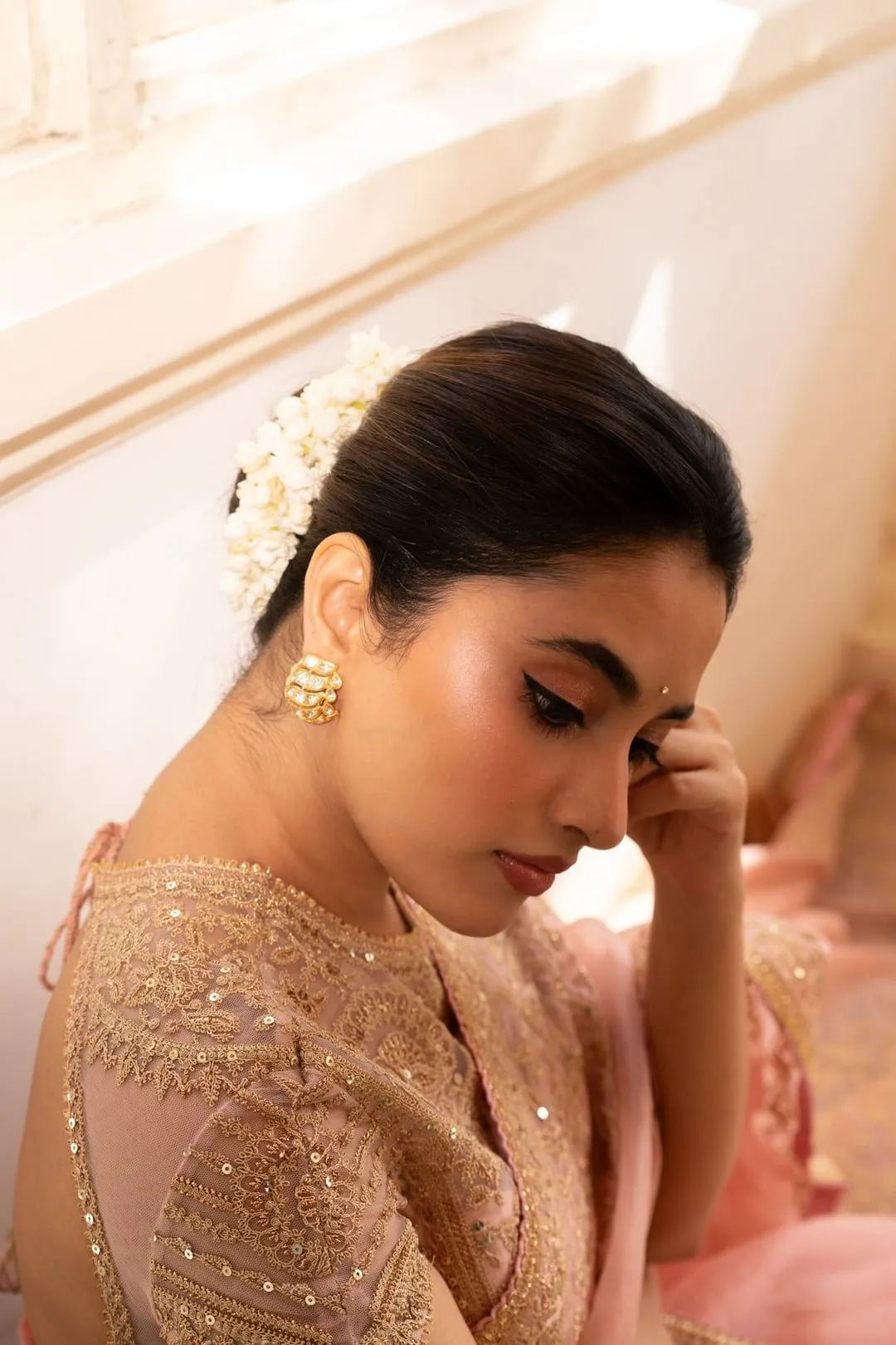 Priyanka Mohan in a Pink Saree Sitting Near a Pink Wall