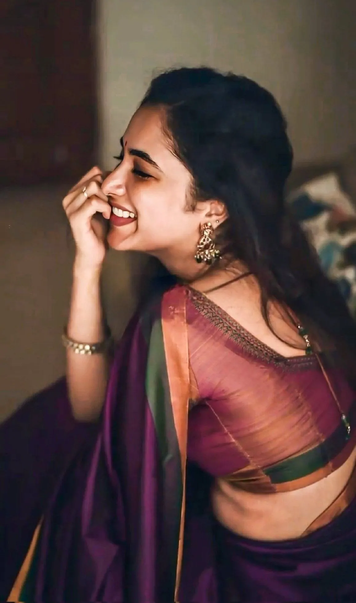 Priyanka Mohan in a Saree Sitting in Dark Lighting Image