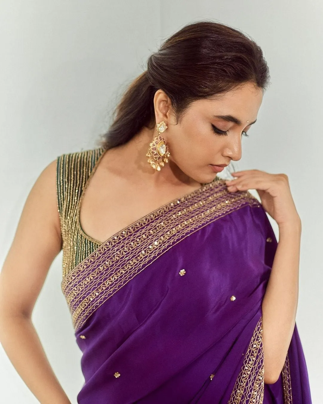 Priyanka Mohan in a Violet Saree Standing Against White Wall