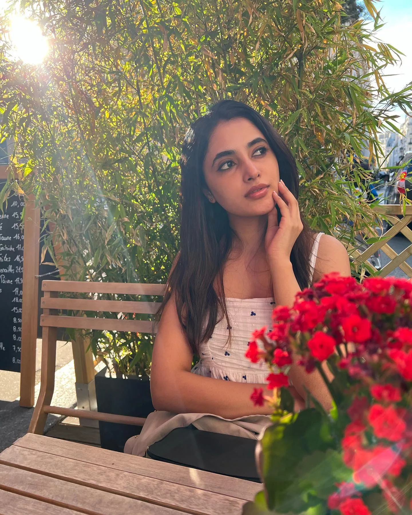 Priyanka Mohan in a White Dress Sitting Near Red Flowers
