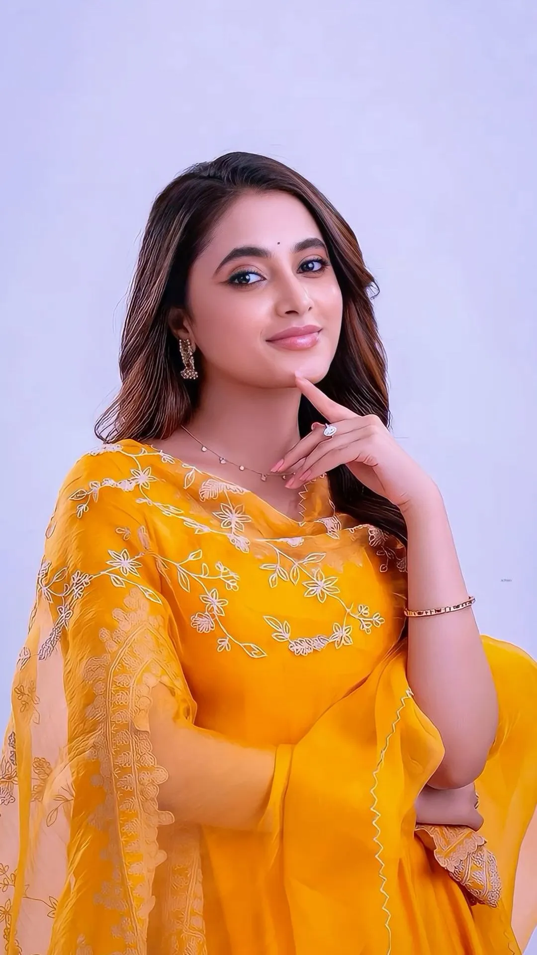 Priyanka Mohan in an Orange Dress Standing Against Blue Wall