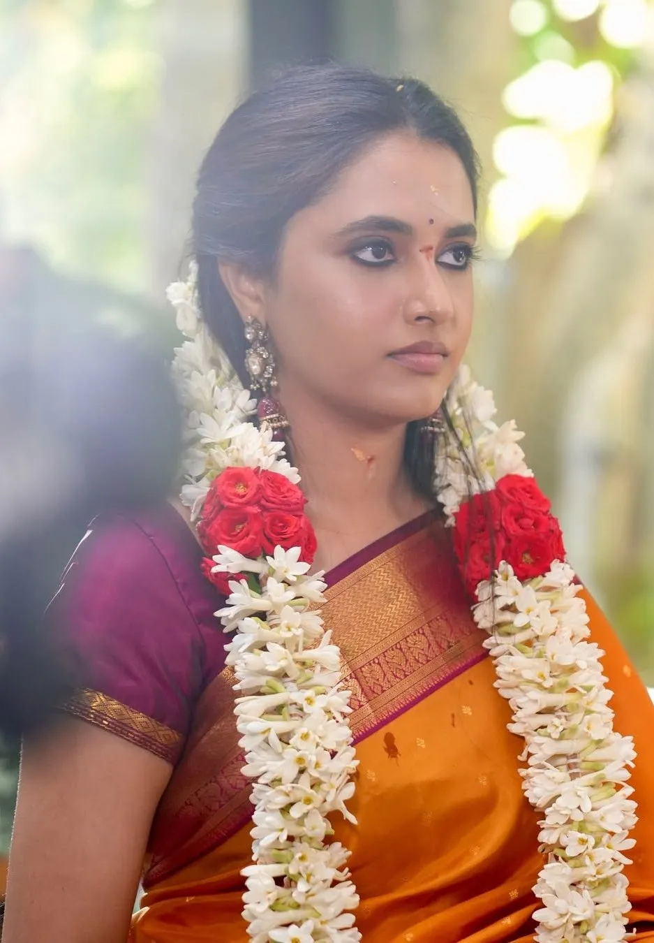 Priyanka Mohan in an Orange Saree with a Flower Garland