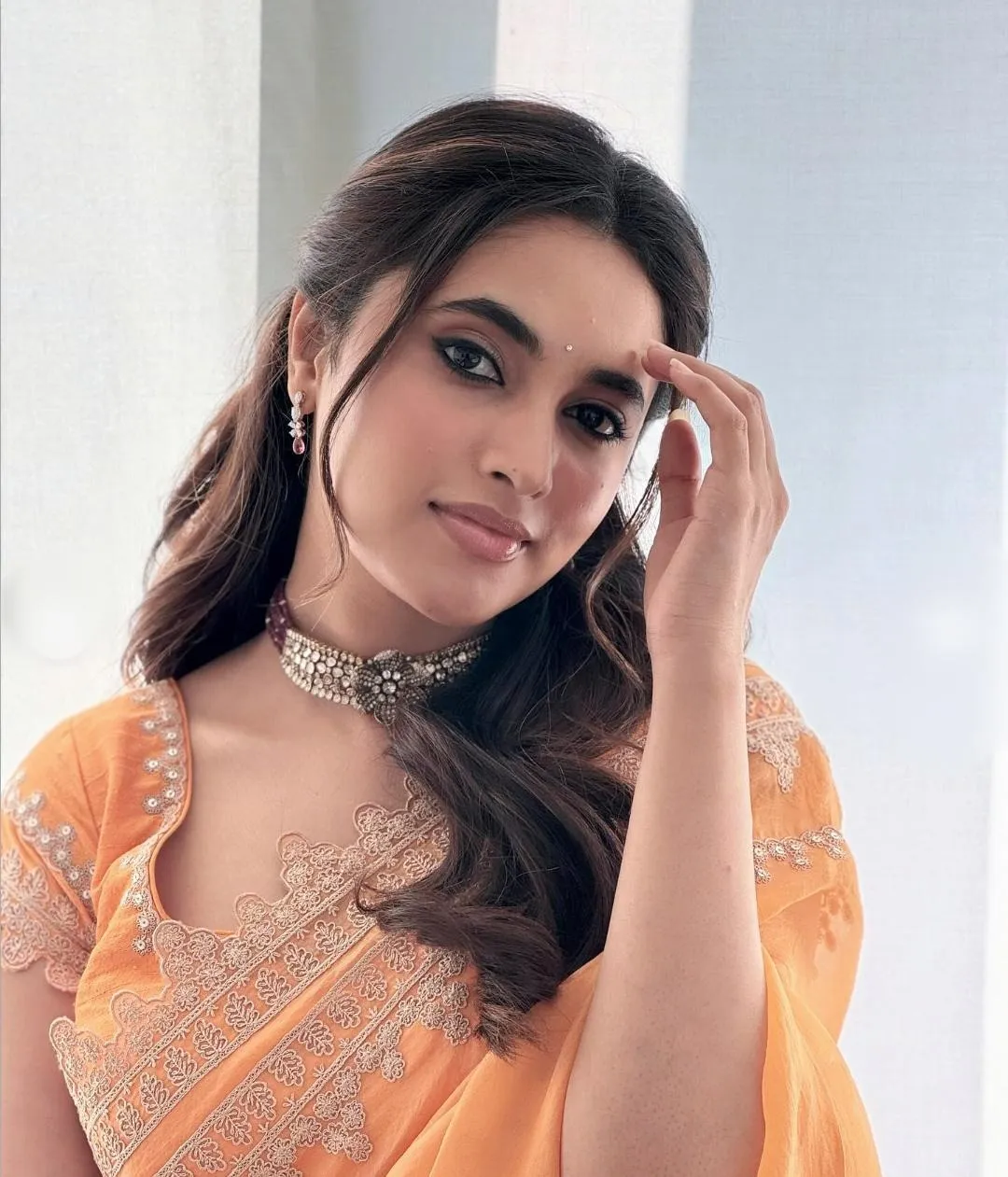 Priyanka Mohan in an Orange Saree with Her Hand on Her Head