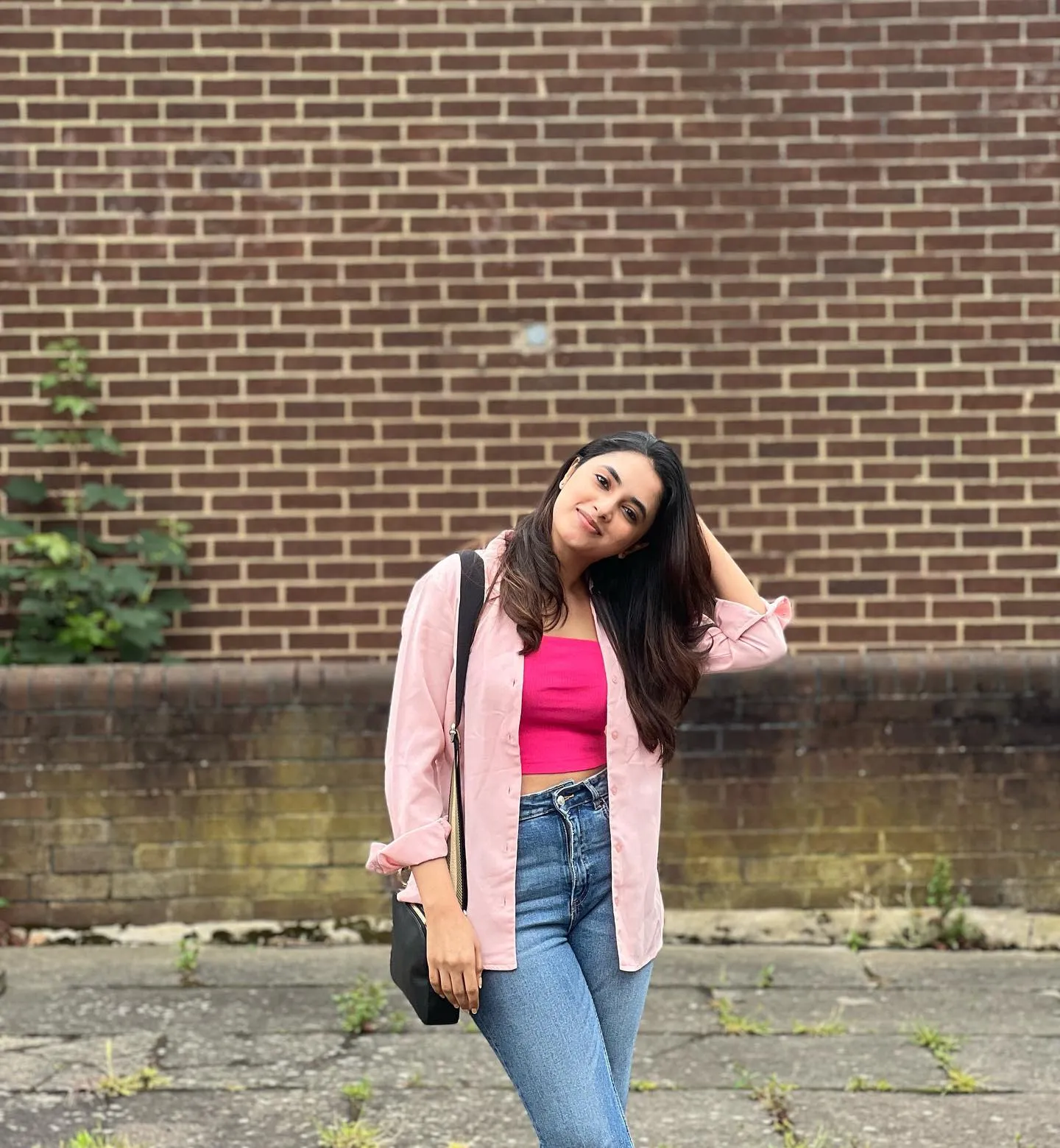 Priyanka Mohan in Pink Top And Jeans Standing Near the Wall