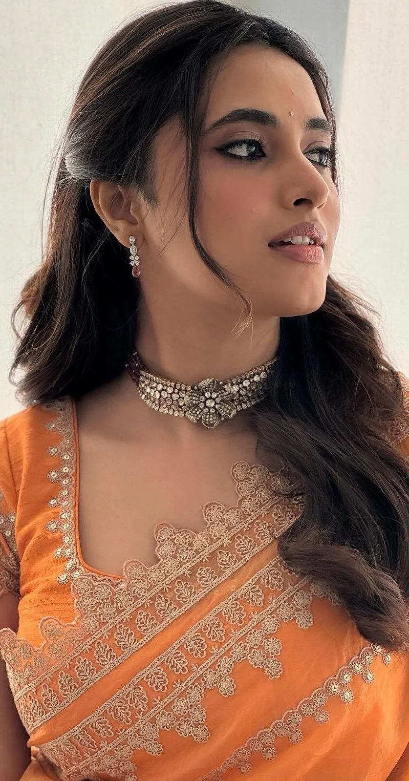 Priyanka Mohan Looking Side Pose Wearing an Orange Saree