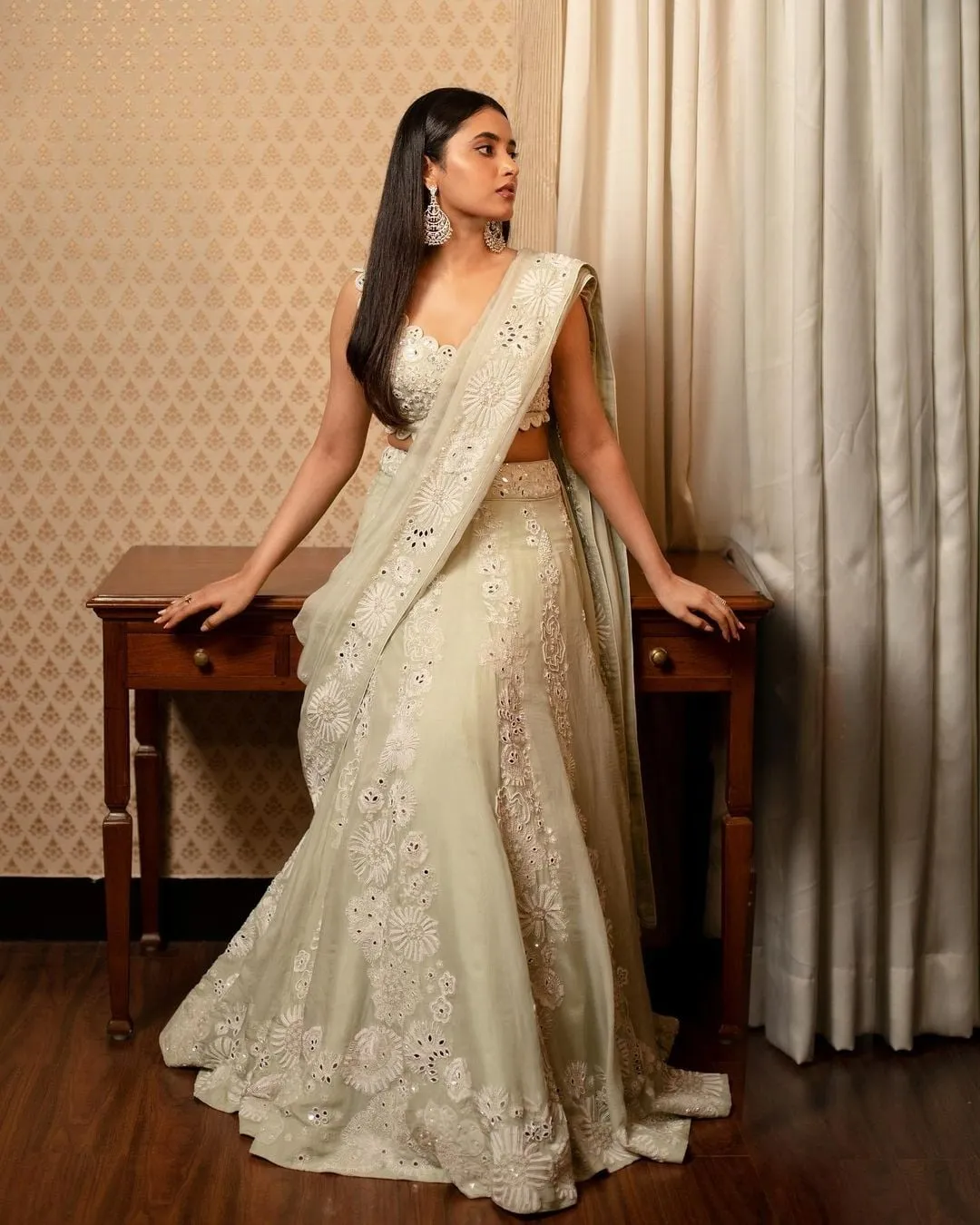 Priyanka Mohan Sitting at Wooden Table Wearing a White Dress