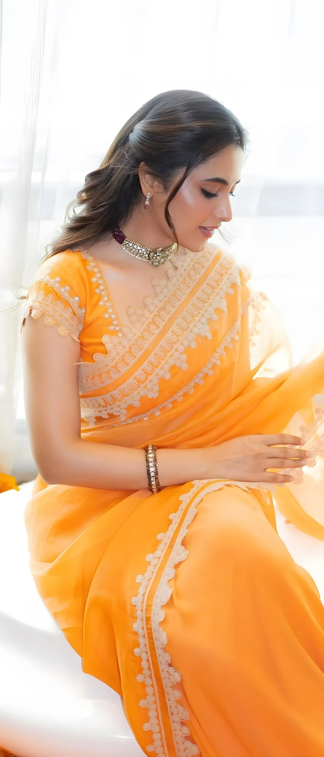 Priyanka Mohan Sitting in a Studio Wearing an Orange Saree