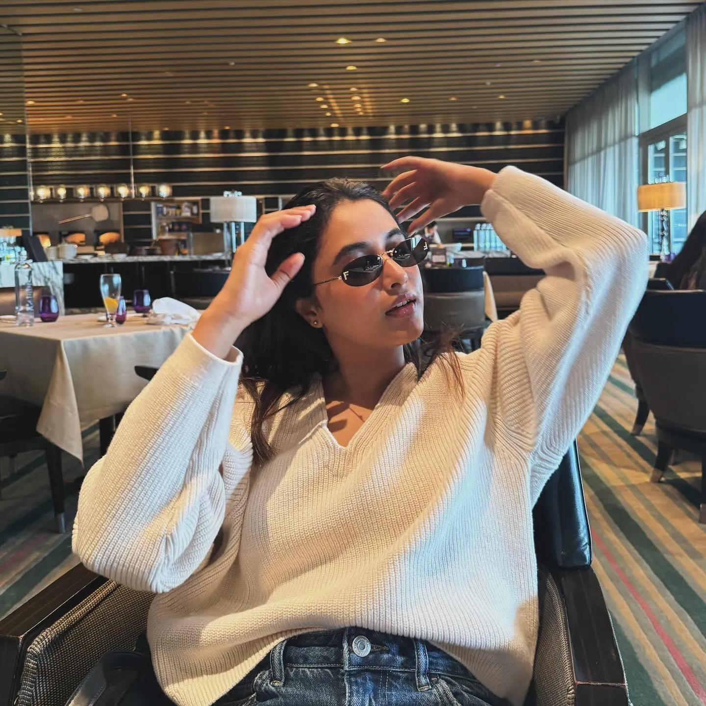 Priyanka Mohan Sitting in Restaurant with Hand Raised Pose