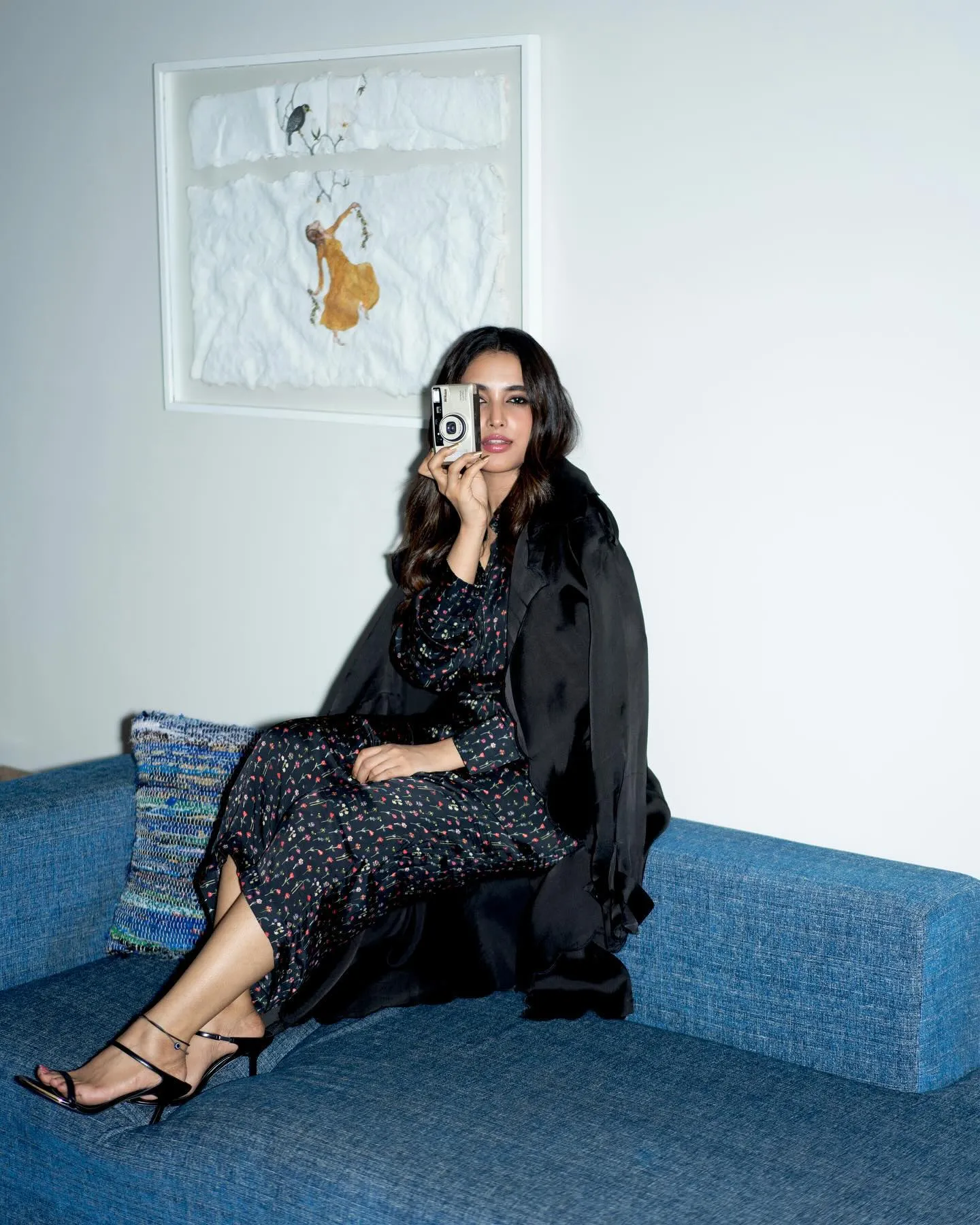Priyanka Mohan Sitting on a Blue Couch Holding a Camera