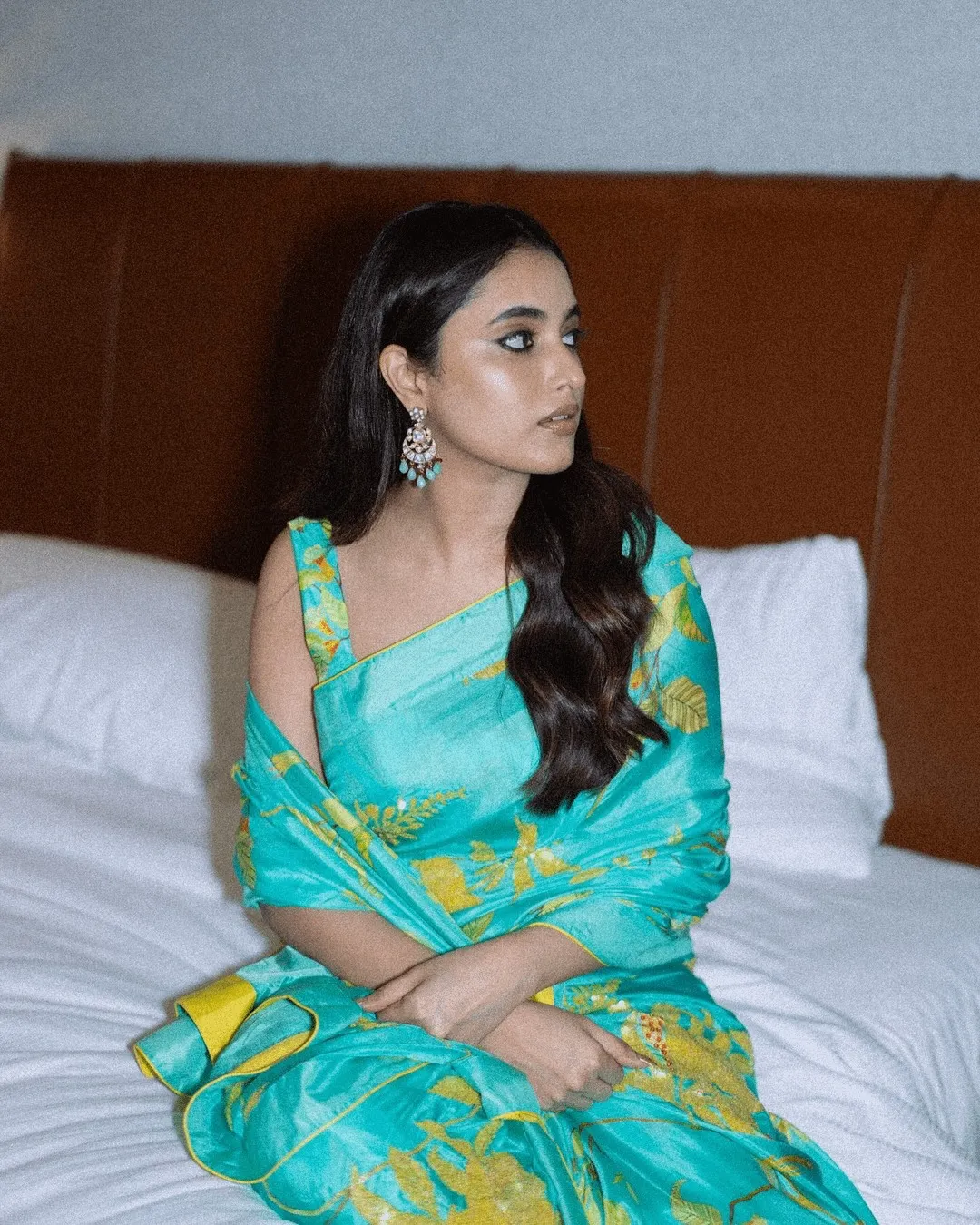 Priyanka Mohan Sitting on the White Bed Wearing a Blue Saree