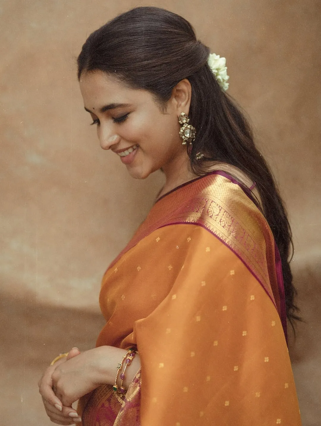 Priyanka Mohan Standing Near Orange Curtain Wearing Saree