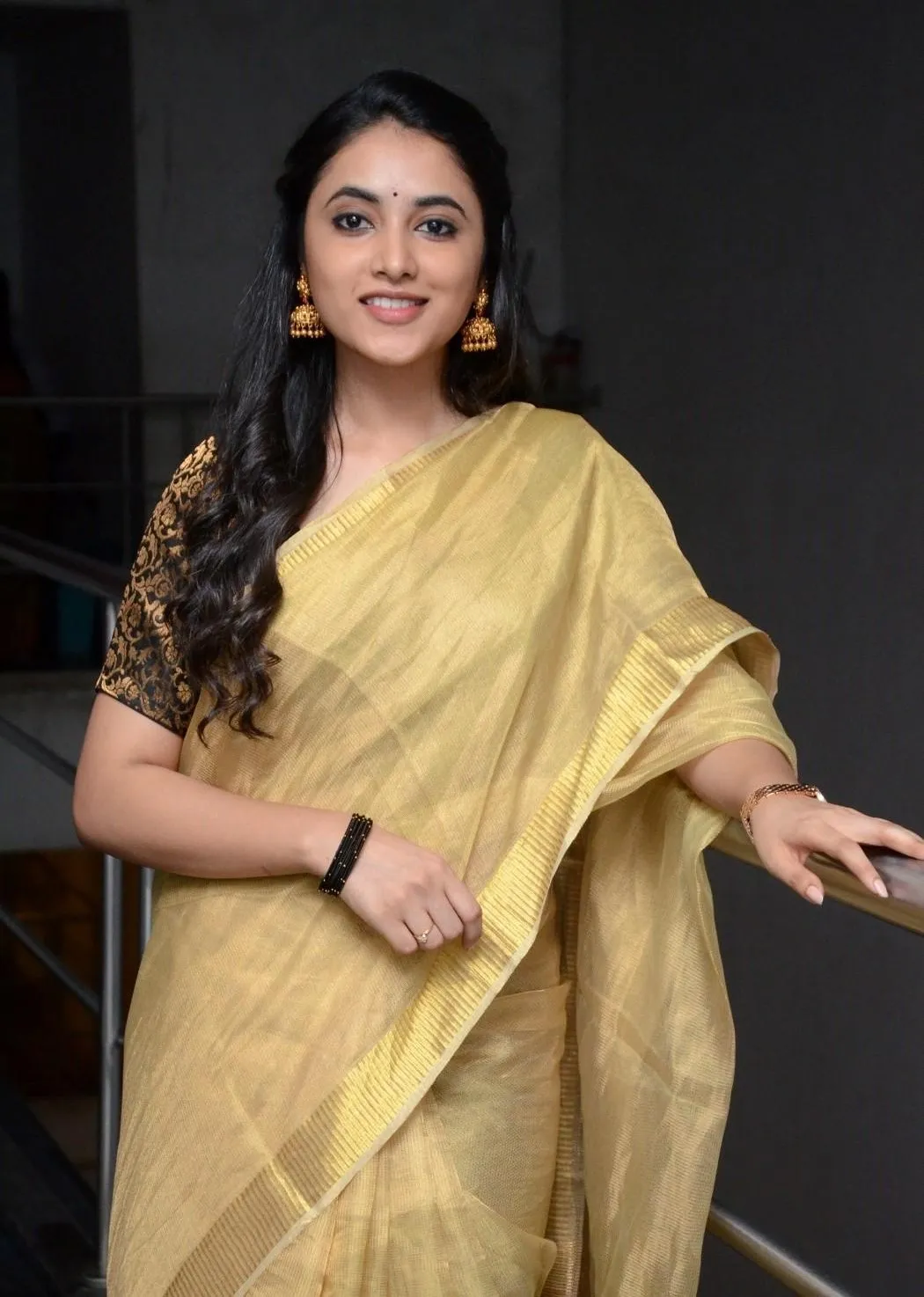 Priyanka Mohan Standing Near the Fence Wearing Golden Saree