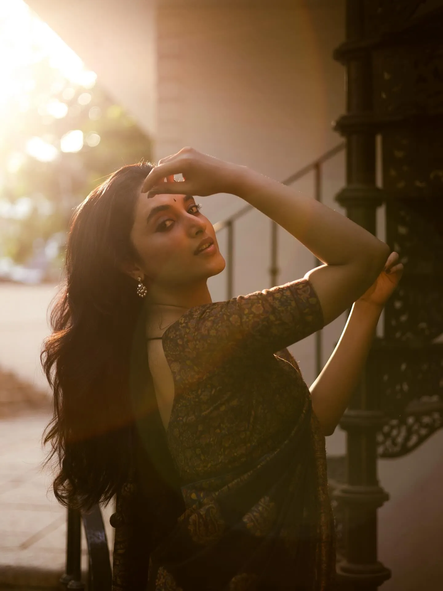 Priyanka posing with hand above head in evening sunlight