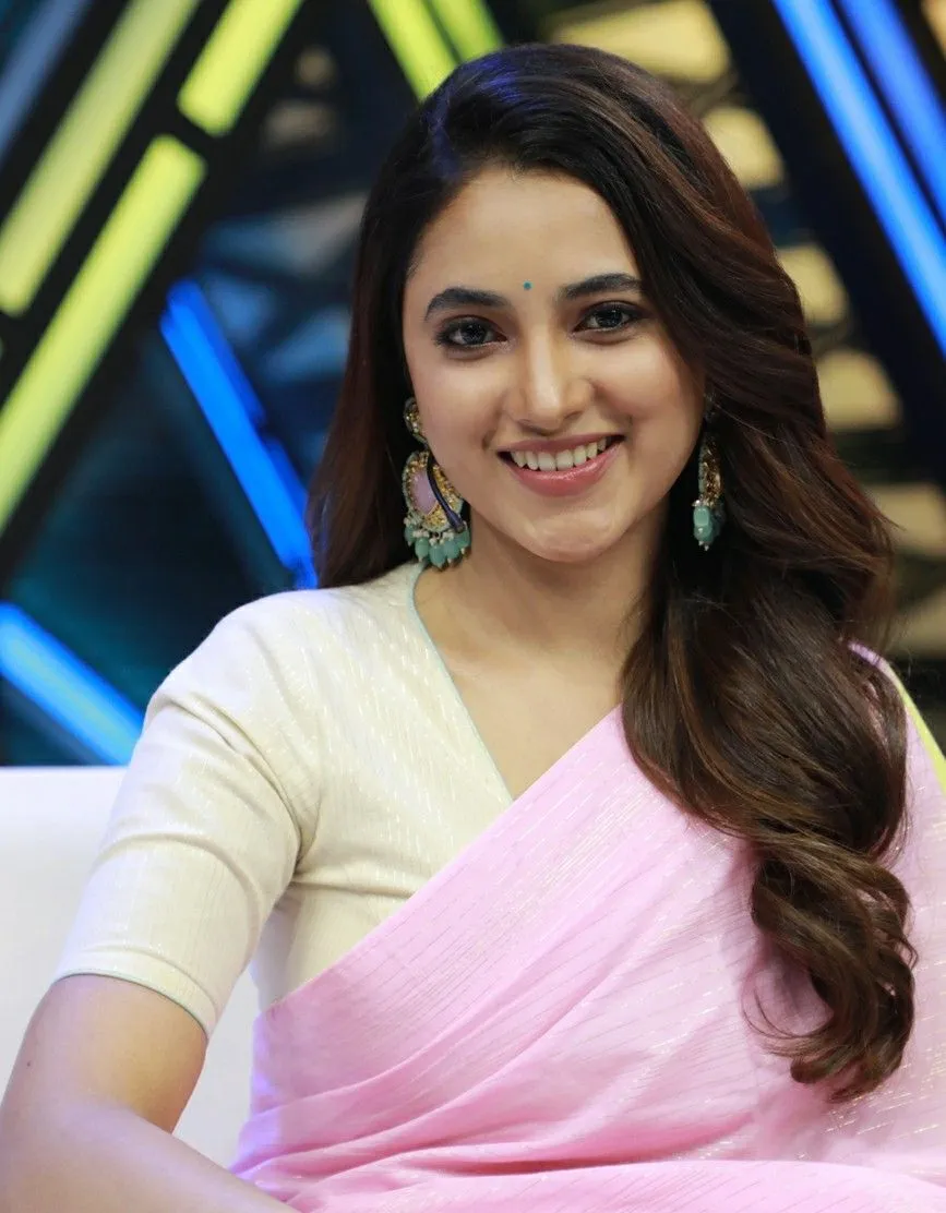 Priyanka smiling brightly in pink saree on the show set