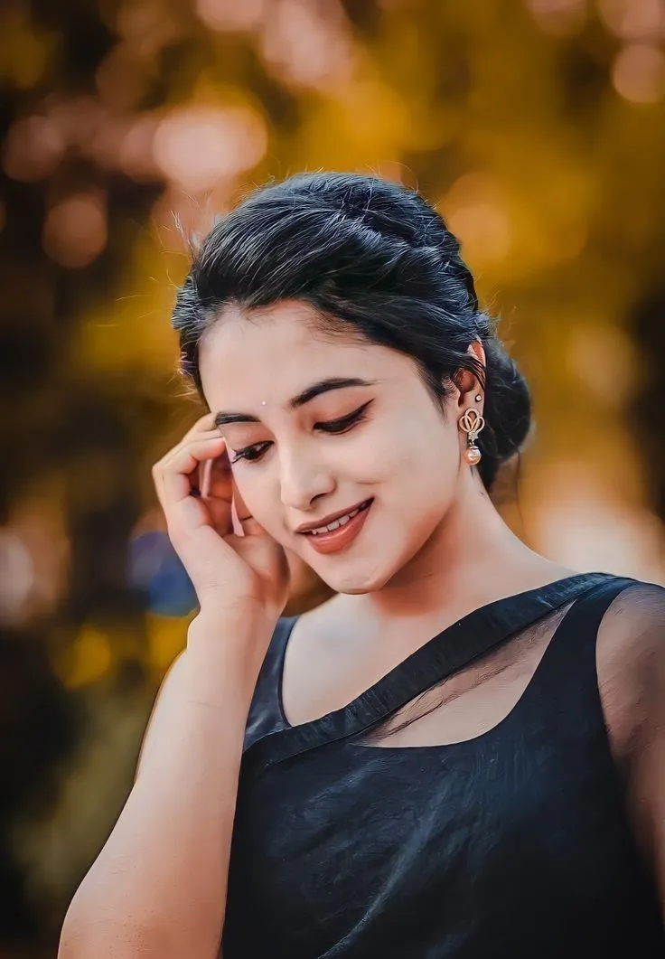 Priyanka smiling with hand near face outdoor lighting
