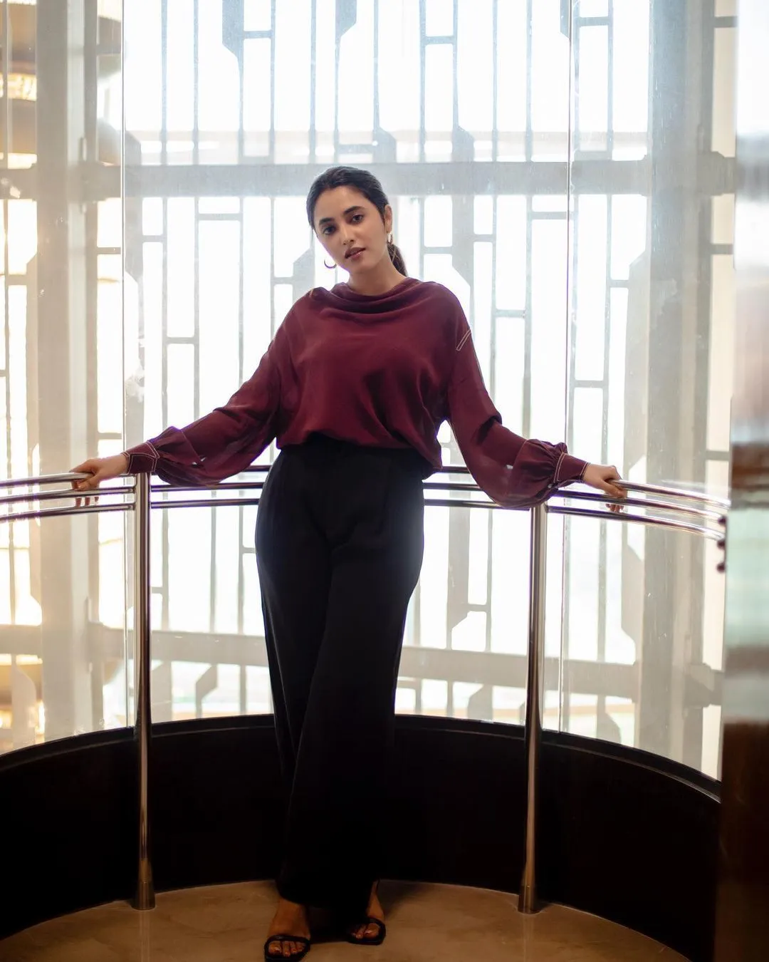 Priyanka standing confidently near bright window light image