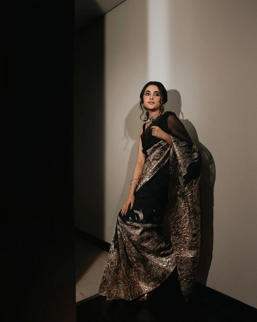 Priyanka striking pose in dramatic black and gold saree