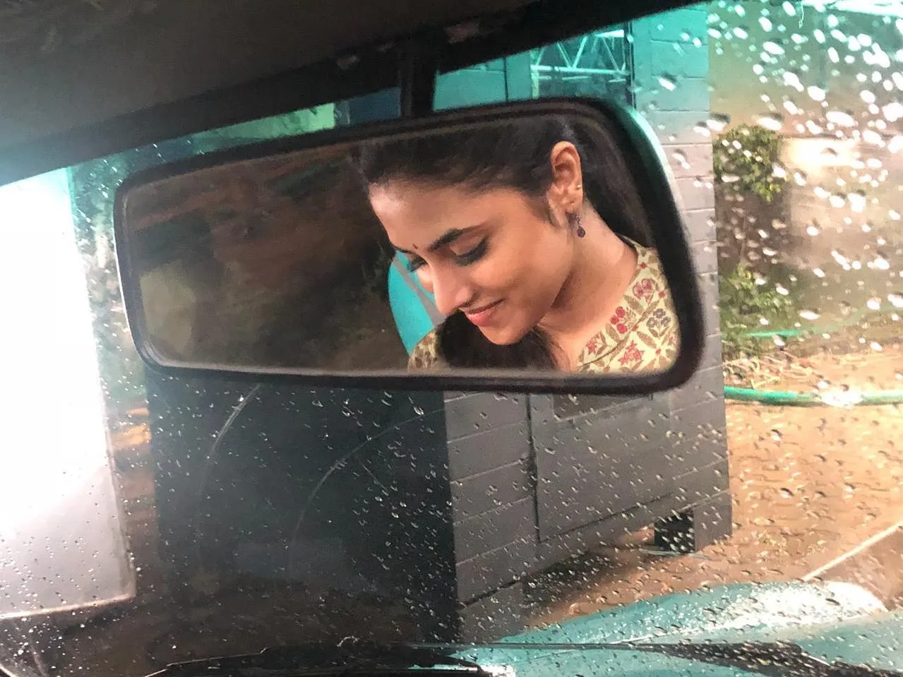 Reflection of Priyanka Arul Mohan in Side Mirror on Rainy Day
