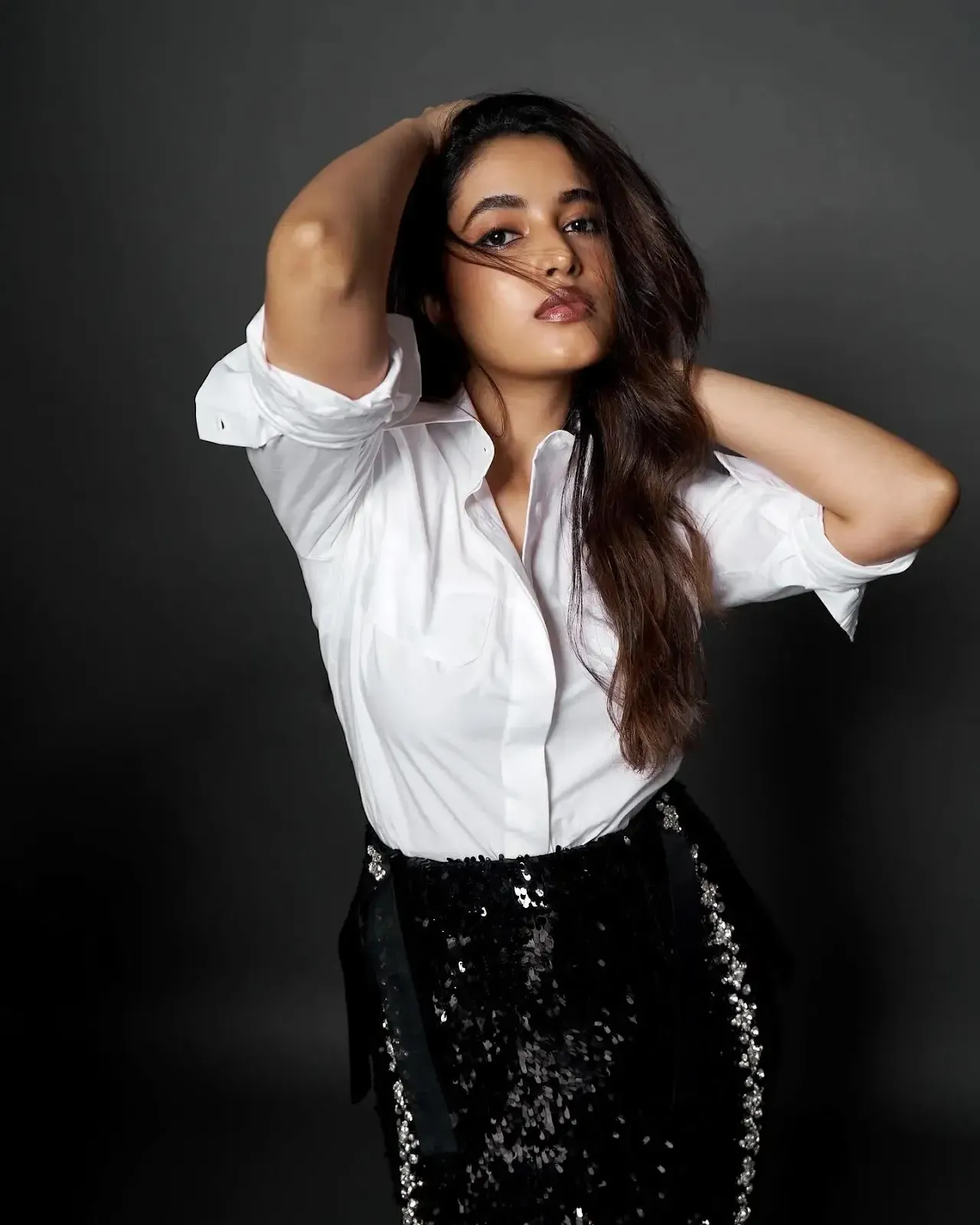 stylish pose of Priyanka Arul Mohan in white shirt and skirt