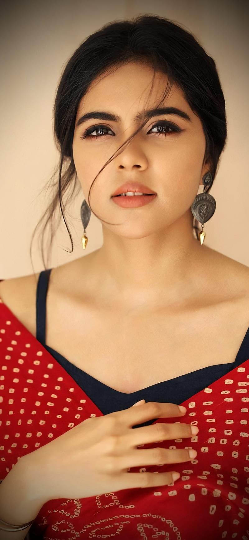 Confident Kalyani in Red Outfit Against Soft Light Image