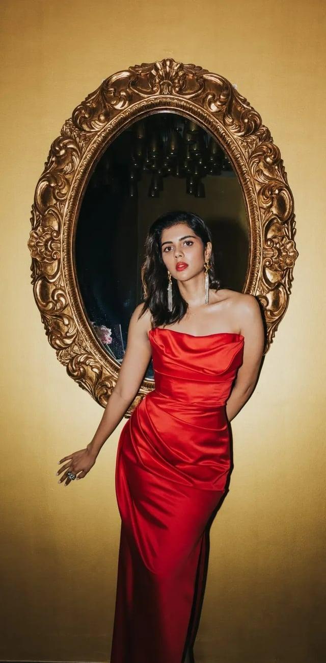 Kalyani in Red Gown Standing Near Vintage Mirror Image