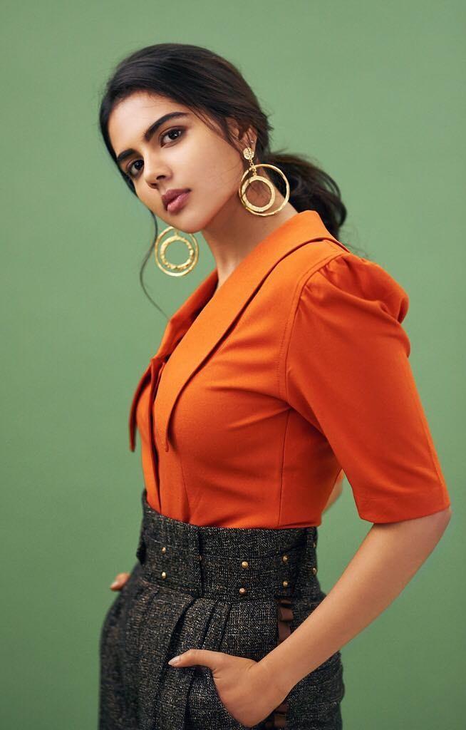 Kalyani Priyadarshan in Orange Top with Green Background