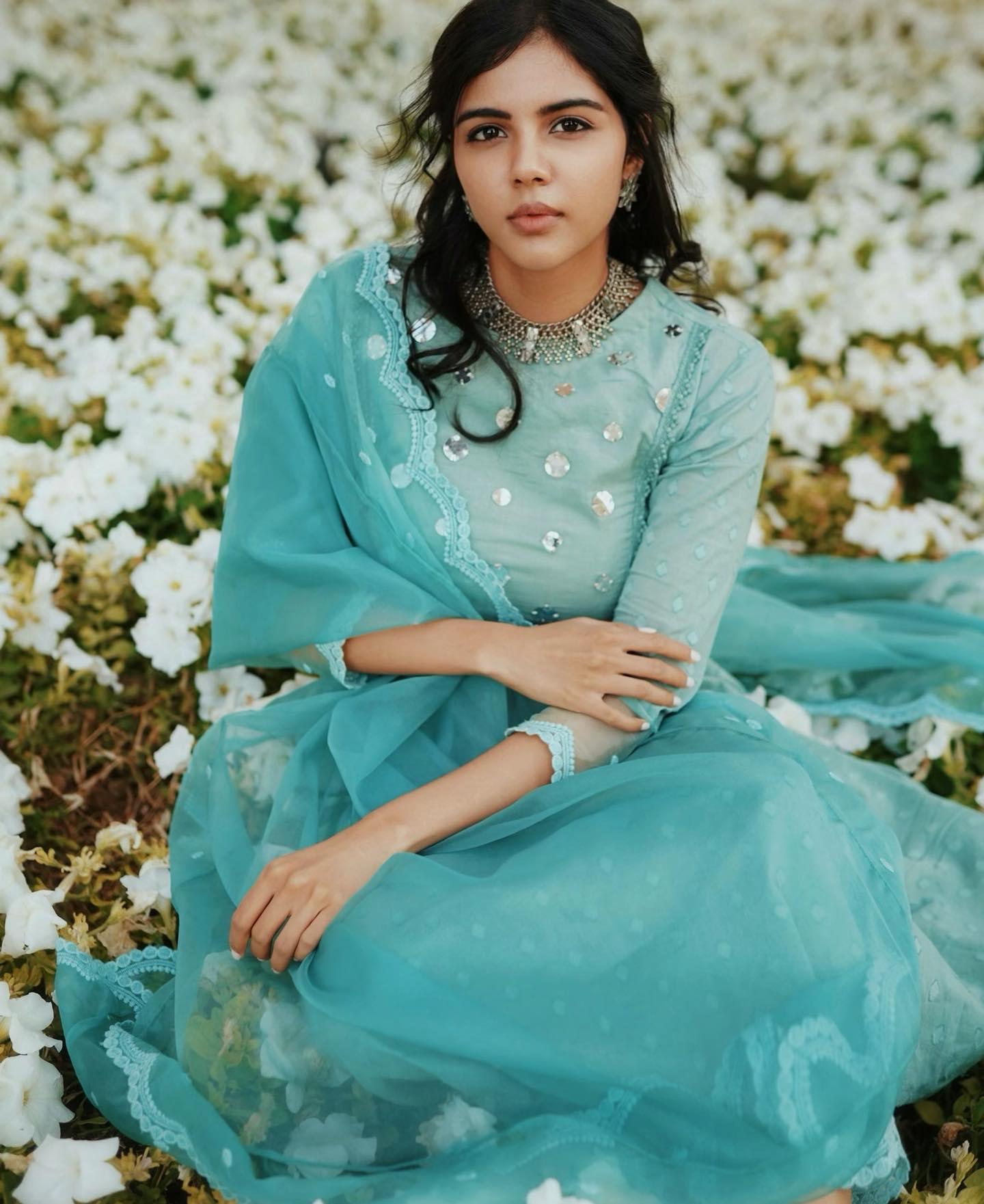 Kalyani Priyadarshan Sitting in White Flower Garden Pic