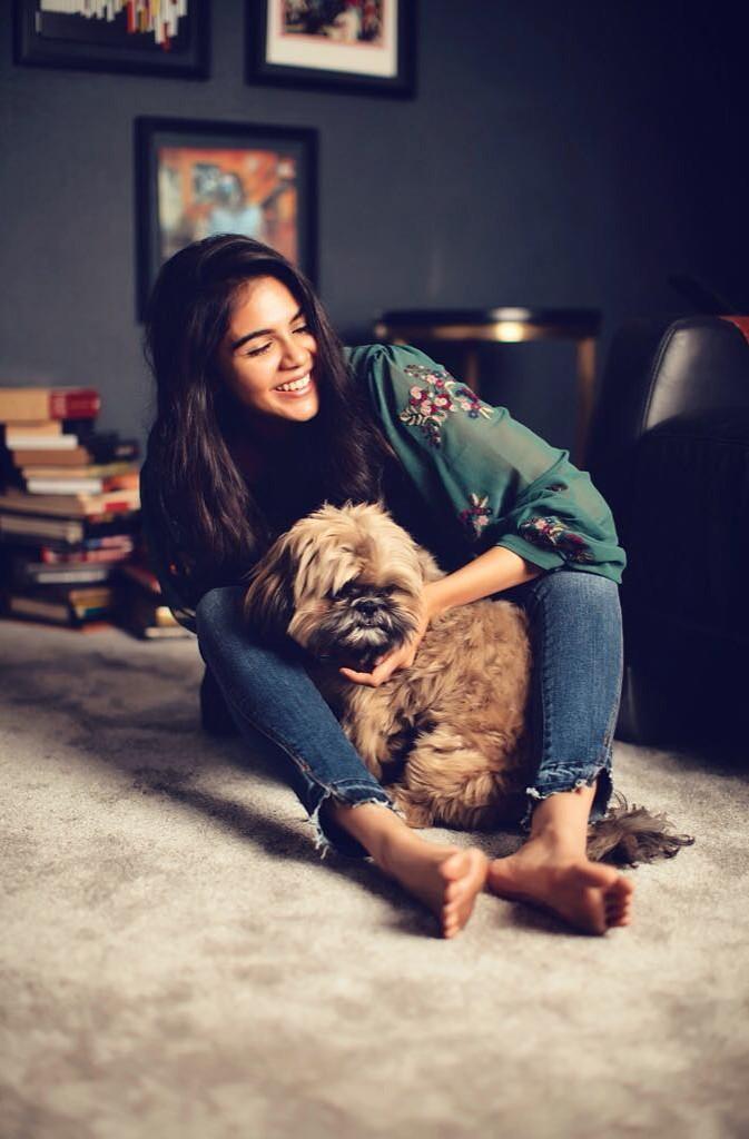 Kalyani Priyadarshan Sitting with Dog in Cozy Room Image