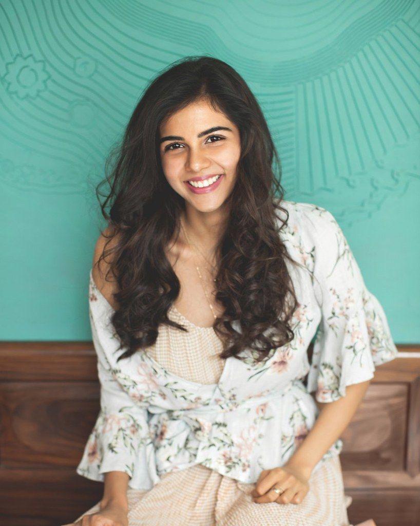 Kalyani Smiling in Floral Top Against Teal Wall Photography