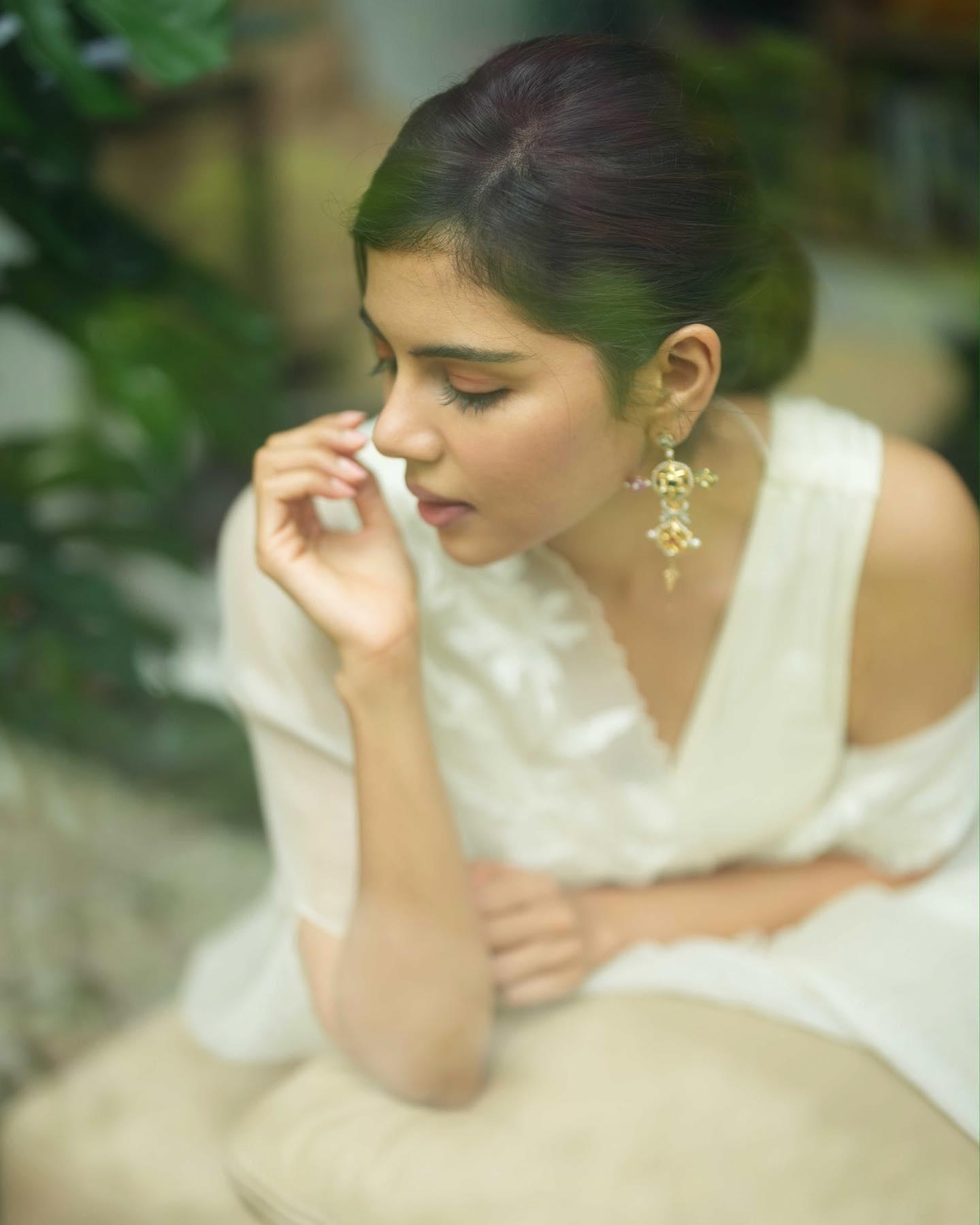 Thoughtful Kalyani in Off Shoulder White Dress Sitting Image