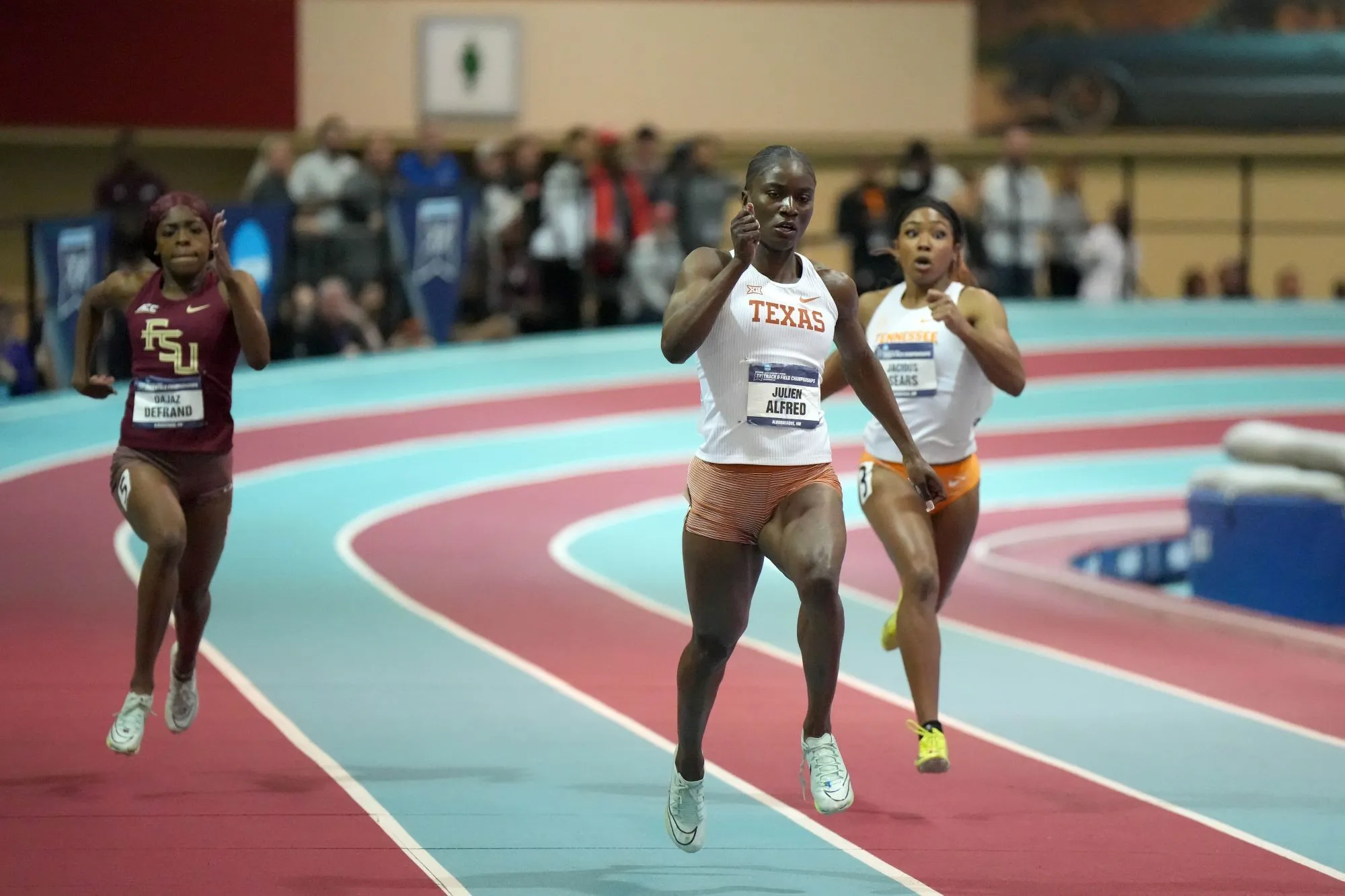 Julien Alfred sprinting powerfully in athletics track event
