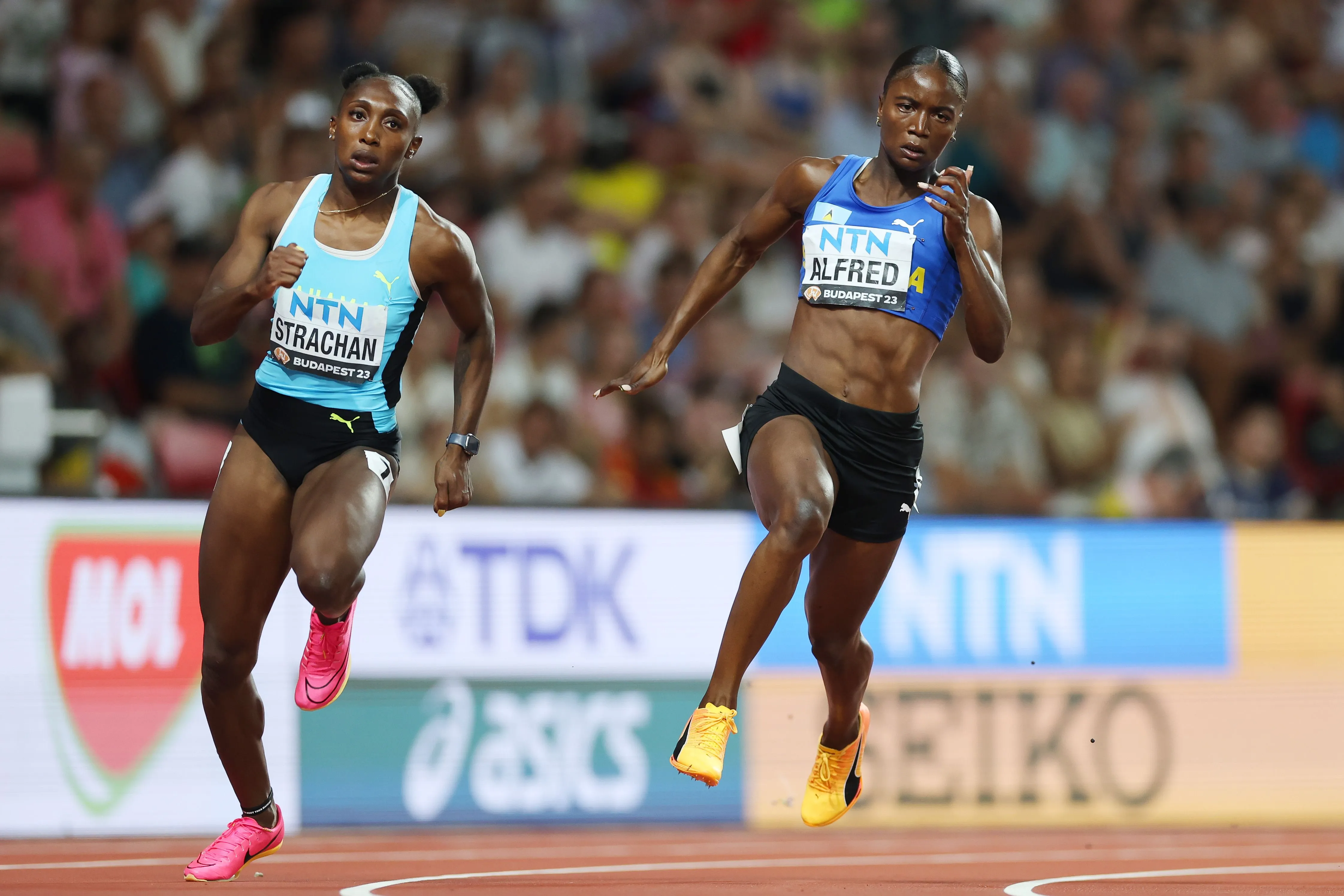 Julien Alfred competing in a packed stadium sprint event