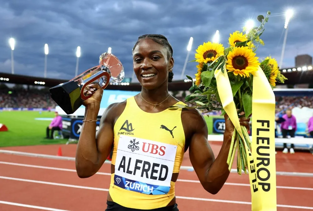 Julien Alfred smiling with fellow athletes after sprint event