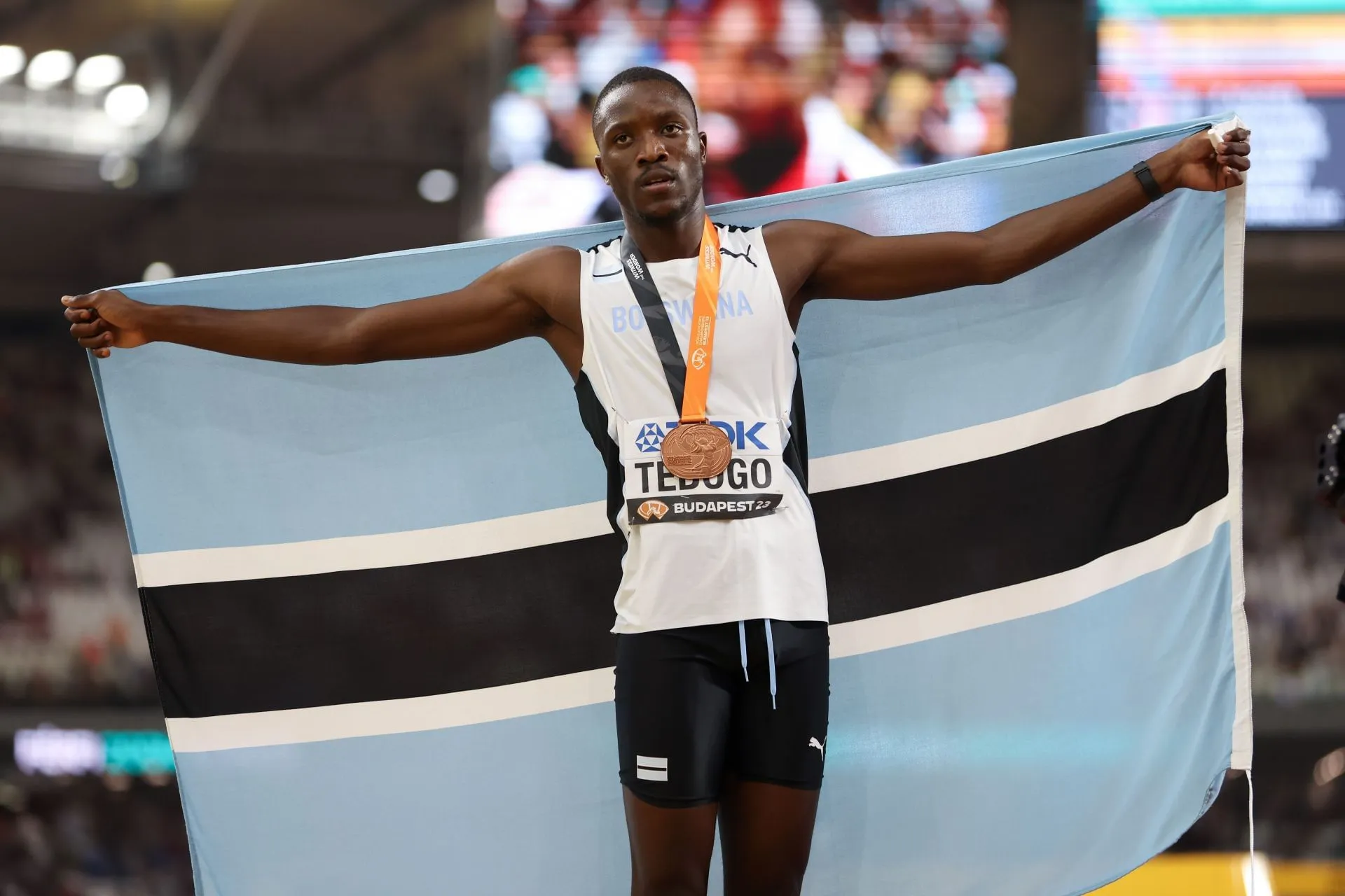 Letsile Tebogo posing in athletics gear with confident smile