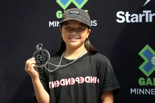 Momiji Nishiya Holding Skateboard Trophy