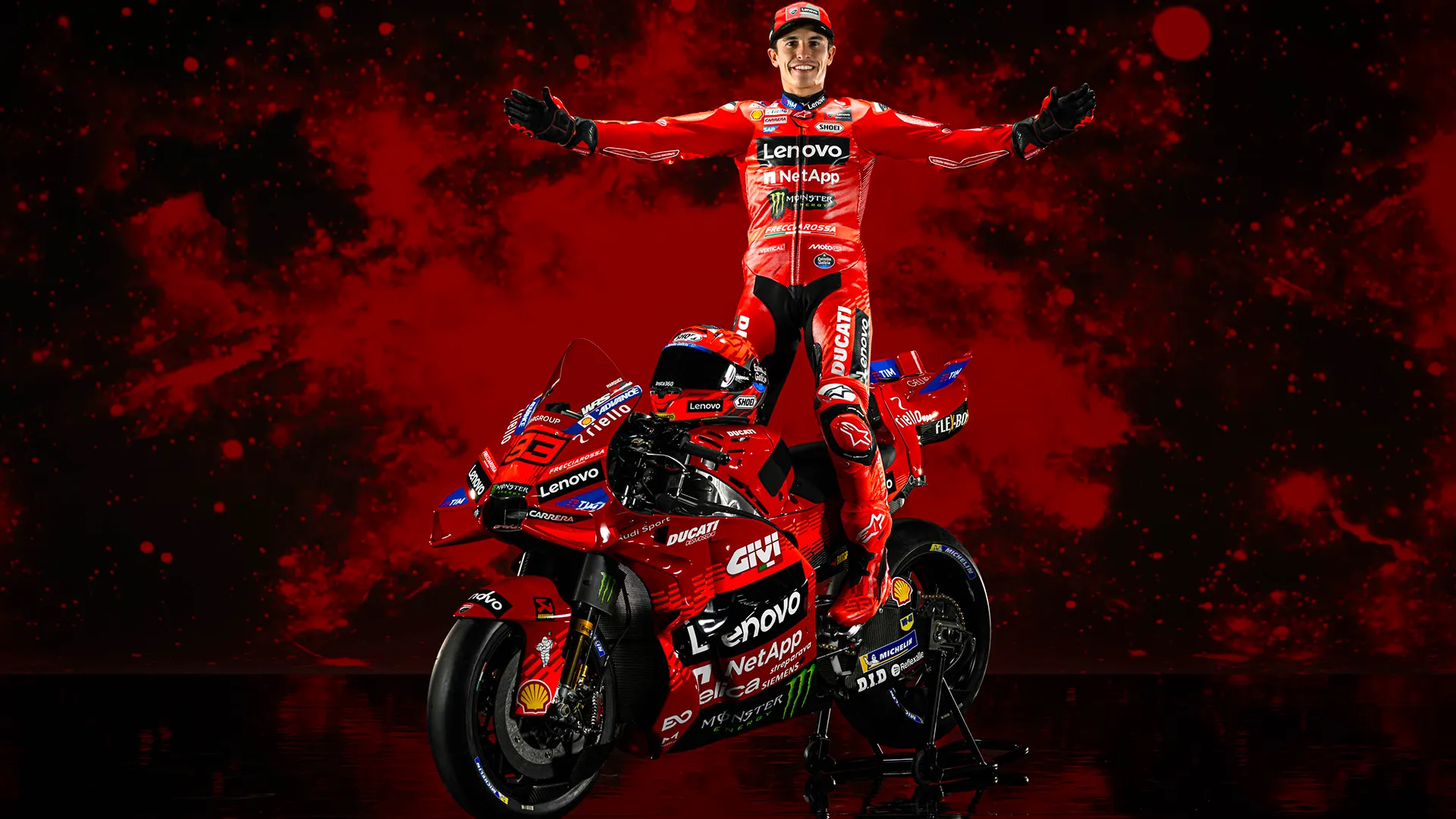 Marc Marquez standing on Ducati bike with arms raised