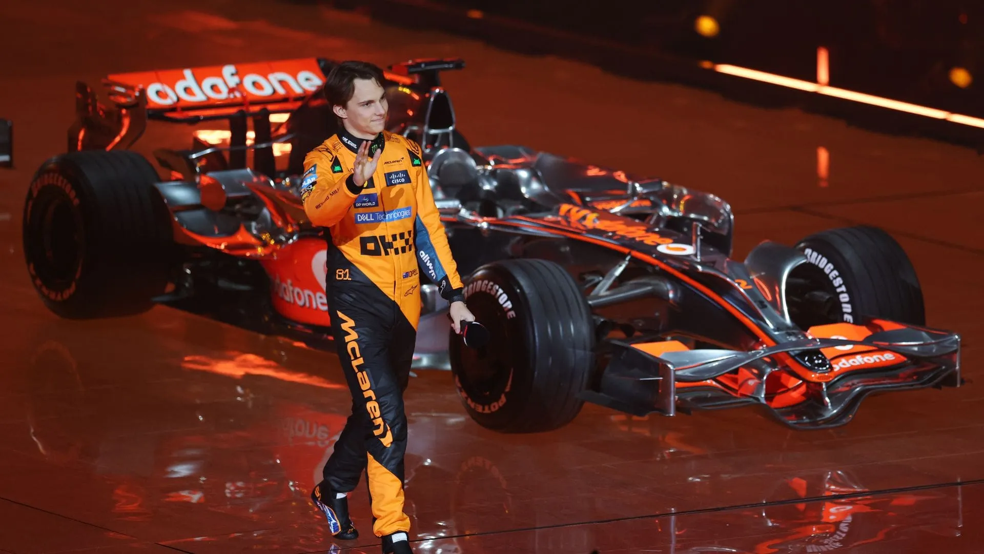Oscar Piastri Celebrates on Stage Beside His McLaren F1 Car