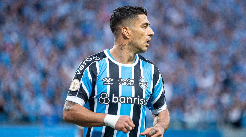Luis Suarez looks on while wearing Gremio home jersey