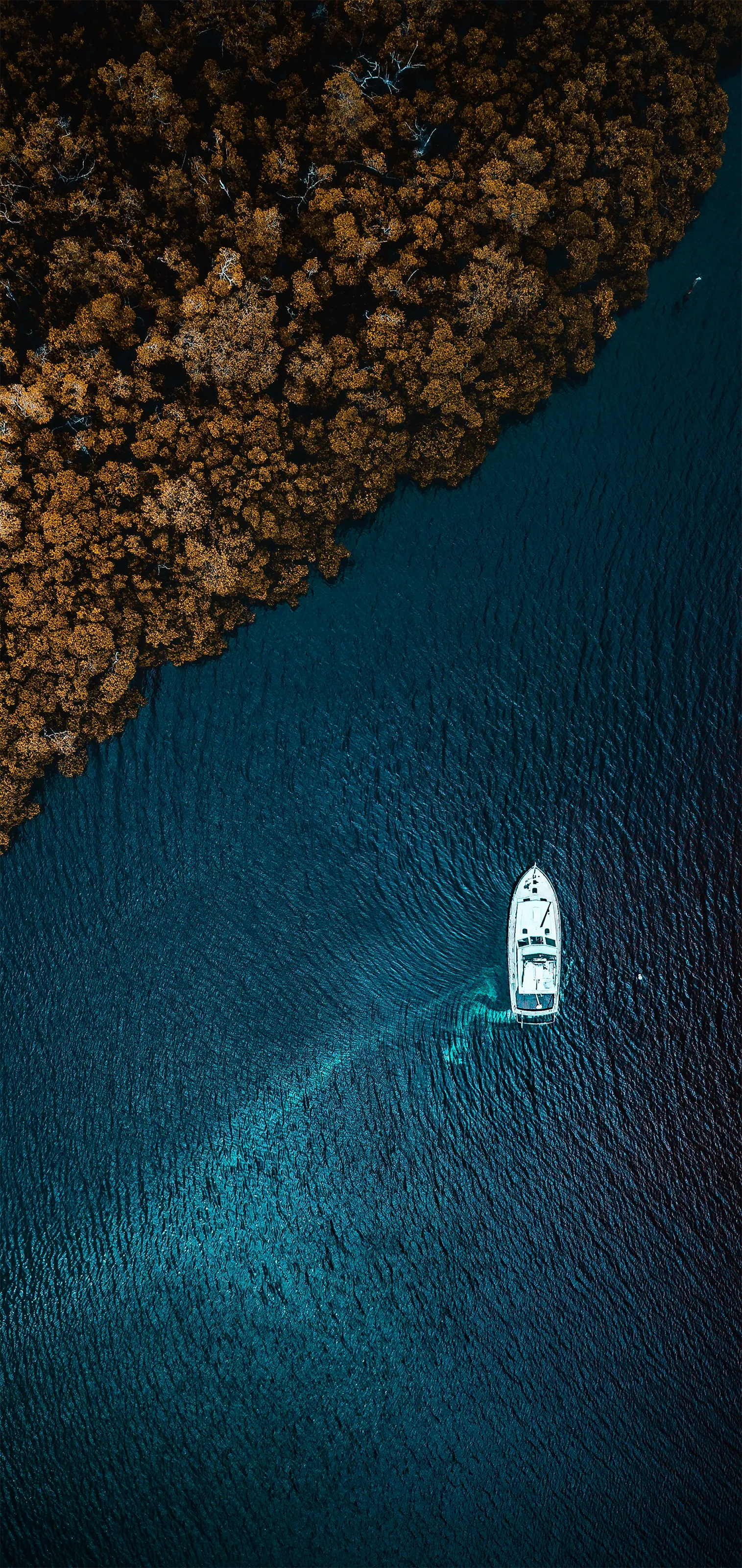 Aerial Drone View of Boat Floating in Blue Water Wallpaper